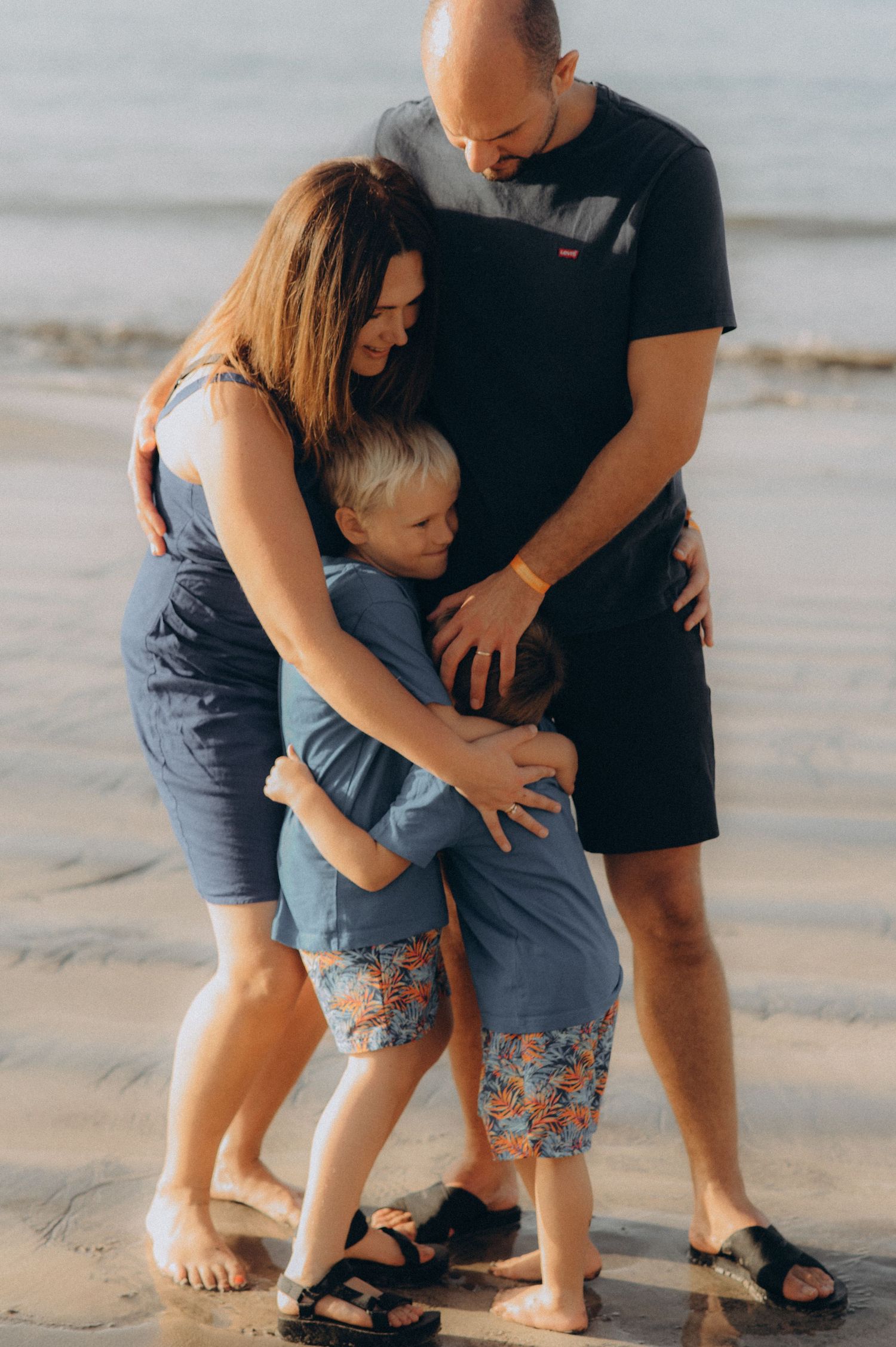 Close-up of the whole family in a group hug, intimate and full of love at Playa Fañabé