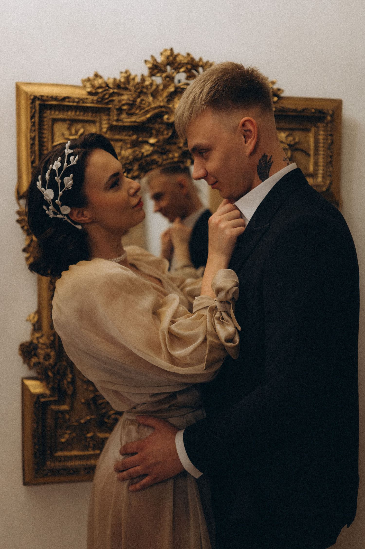 Intimate portrait of a bride and groom standing opposite each other and sharing a quiet moment.