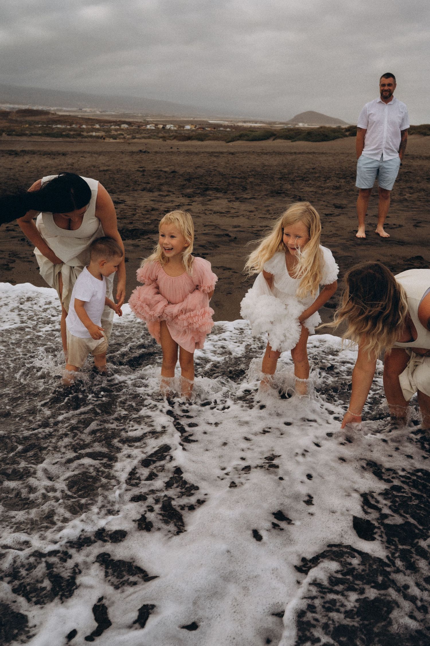 Family enjoying playful moments in the ocean on Playa La Tejita, Tenerife