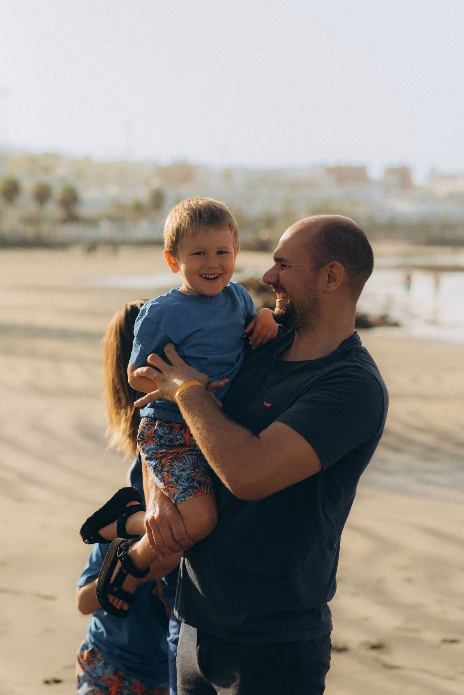 Loving father and son captured enjoying playful moments together in dad’s arms at Playa Fañabé