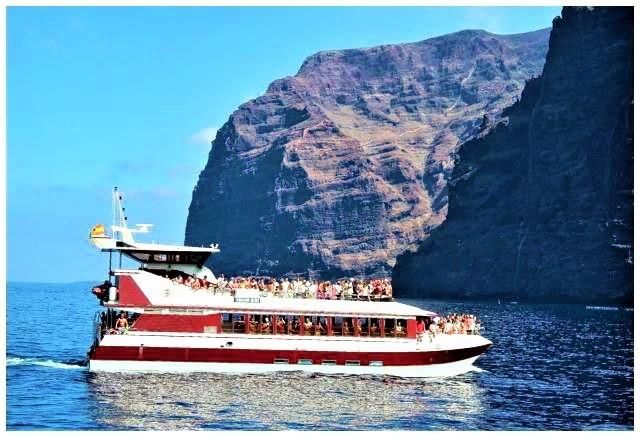 Excursion boat with tourists in front of Los Gigantes, Tenerife coast