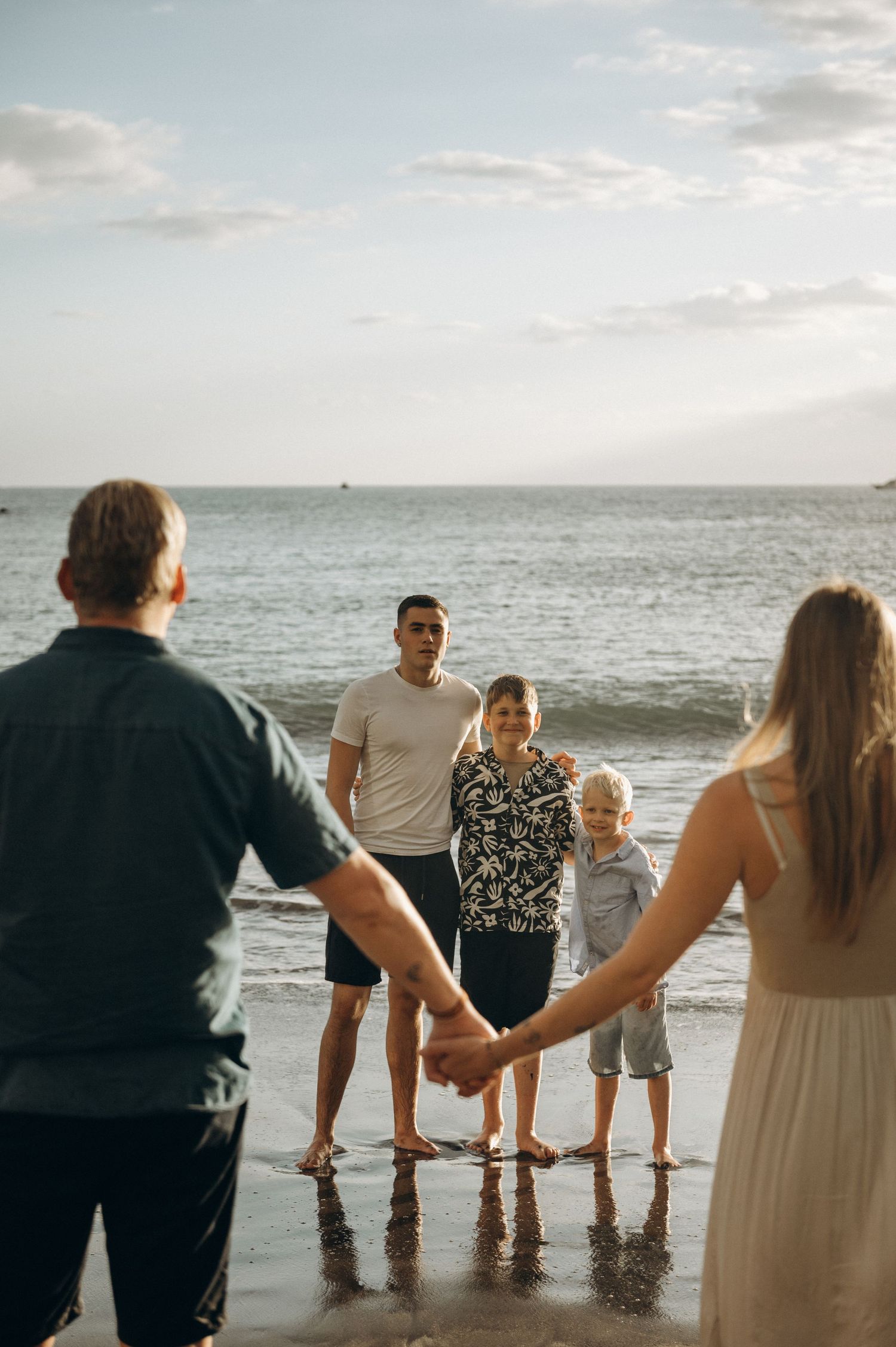 Family moment with parents and three boys near ocean, Tenerife