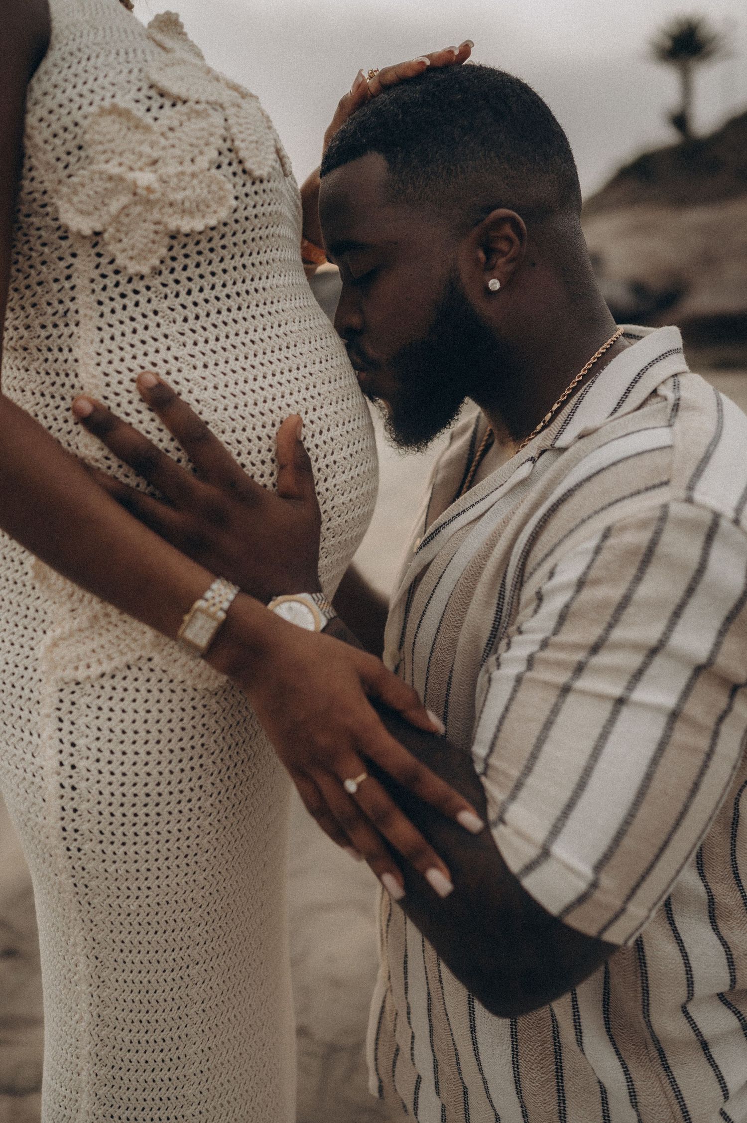 Close-up of man kissing pregnant belly in tender moment