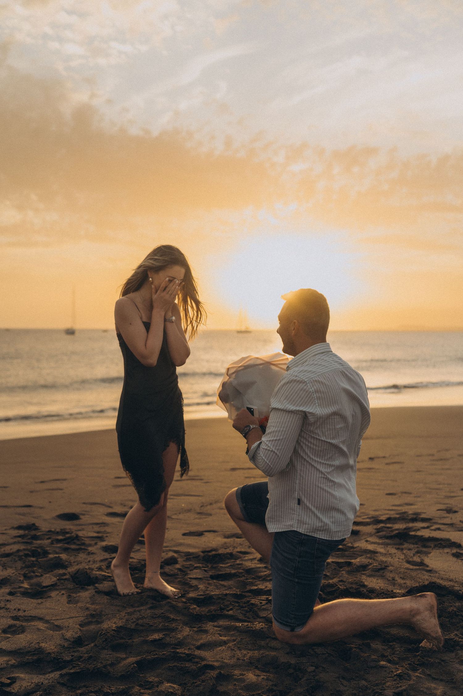Man proposing to his partner at sunset on Playa de La Tejita, Tenerife with Montaña Roja