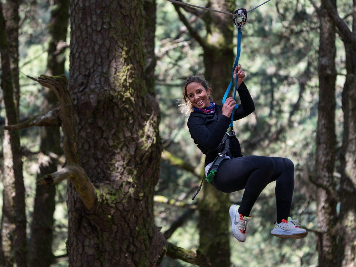 Woman riding zipline through forestal park adventure course, Tenerife