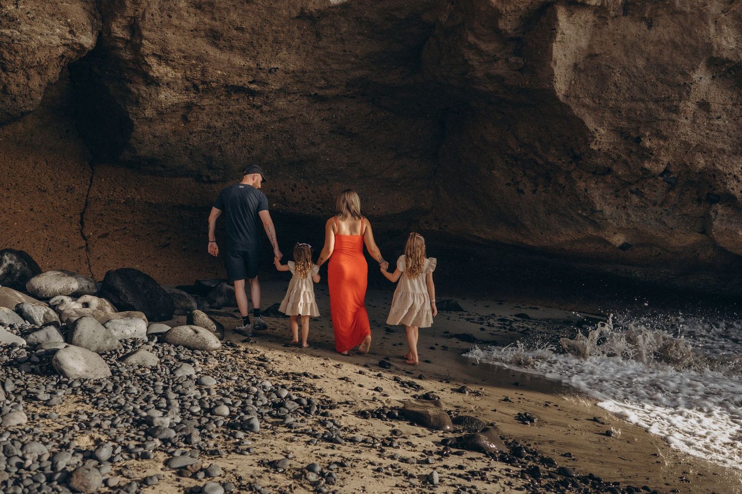 Family enjoying a beach walk holding hands at Playa Morteros, Tenerife coast