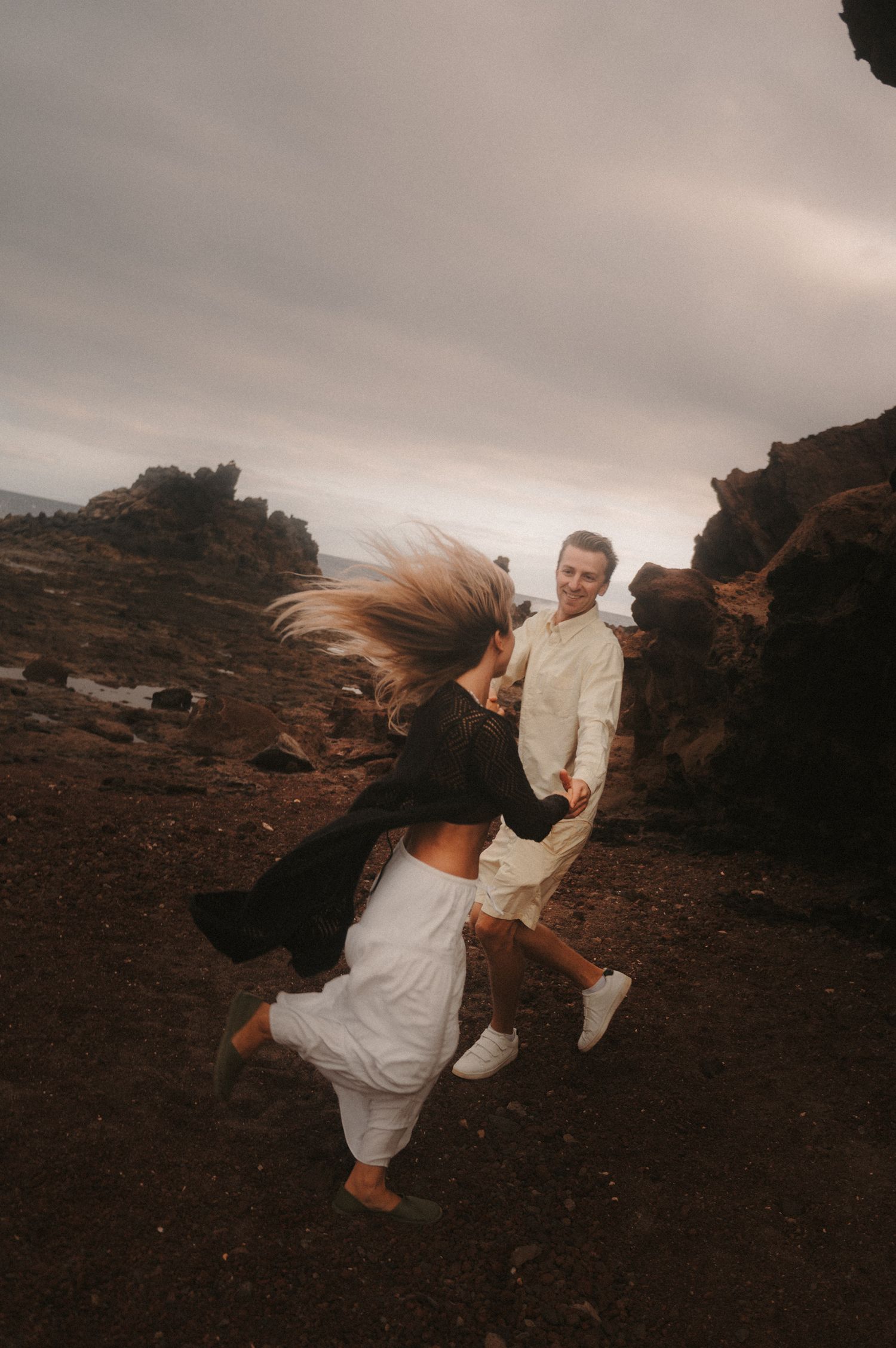 Loving couple dancing under Montaña Roja, looking into each other’s eyes during a romantic photoshoot in Tenerife