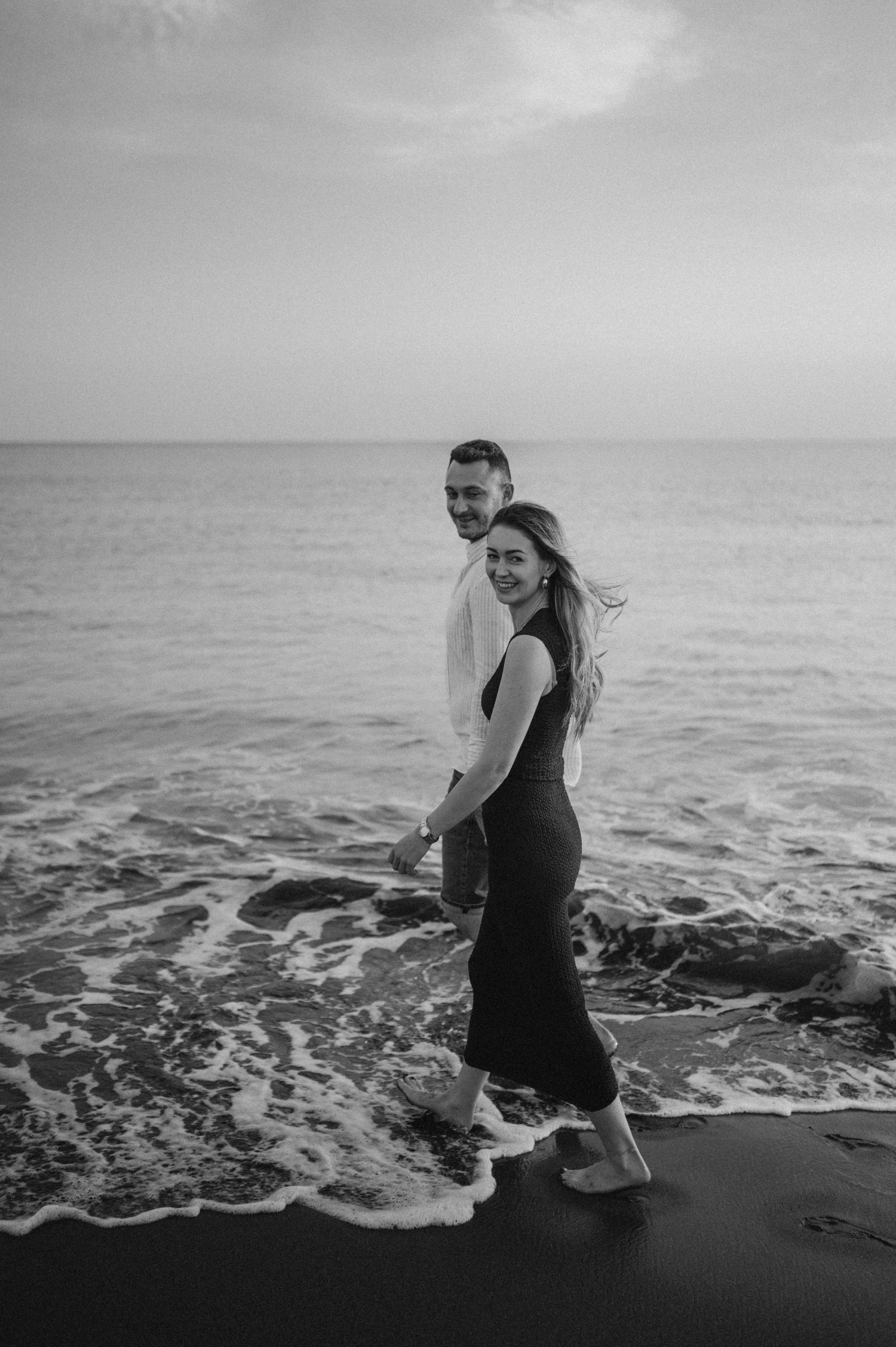 Young couple holding hands and enjoying sunset by Montaña Roja on Playa de La Tejita, Tenerife