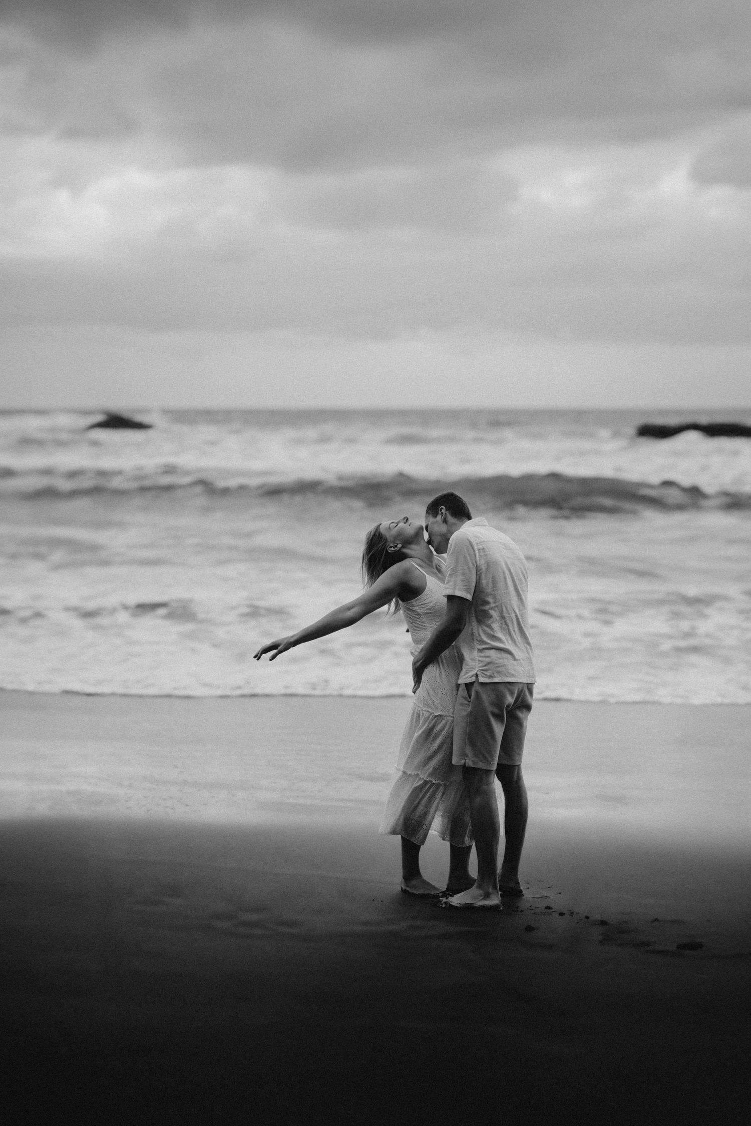 Romantic couple on beach with hands spread, ocean in background, Anaga Park Tenerife