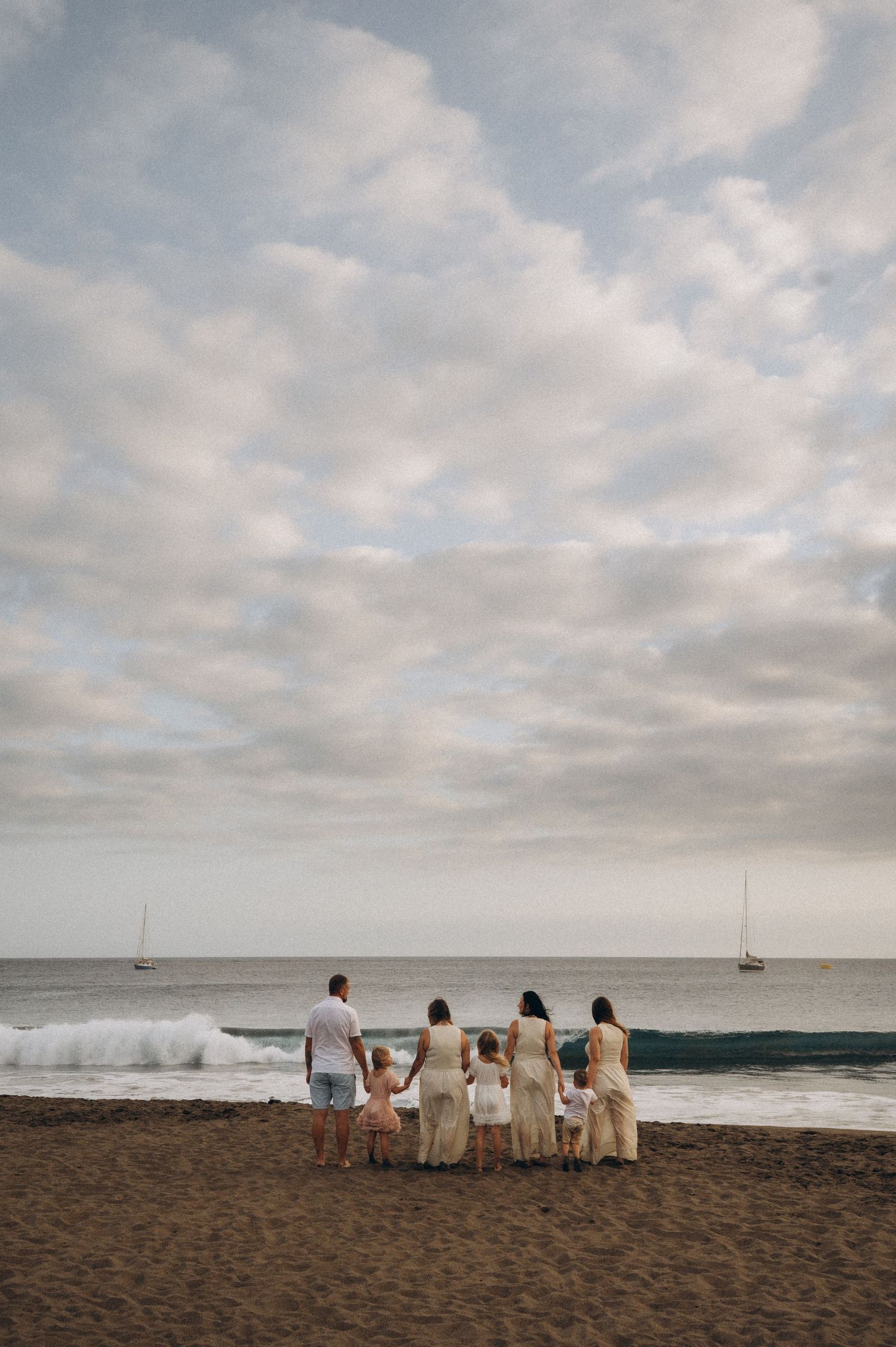 Full family walking hand in hand along beach with Atlantic Ocean, Playa La Tejita
