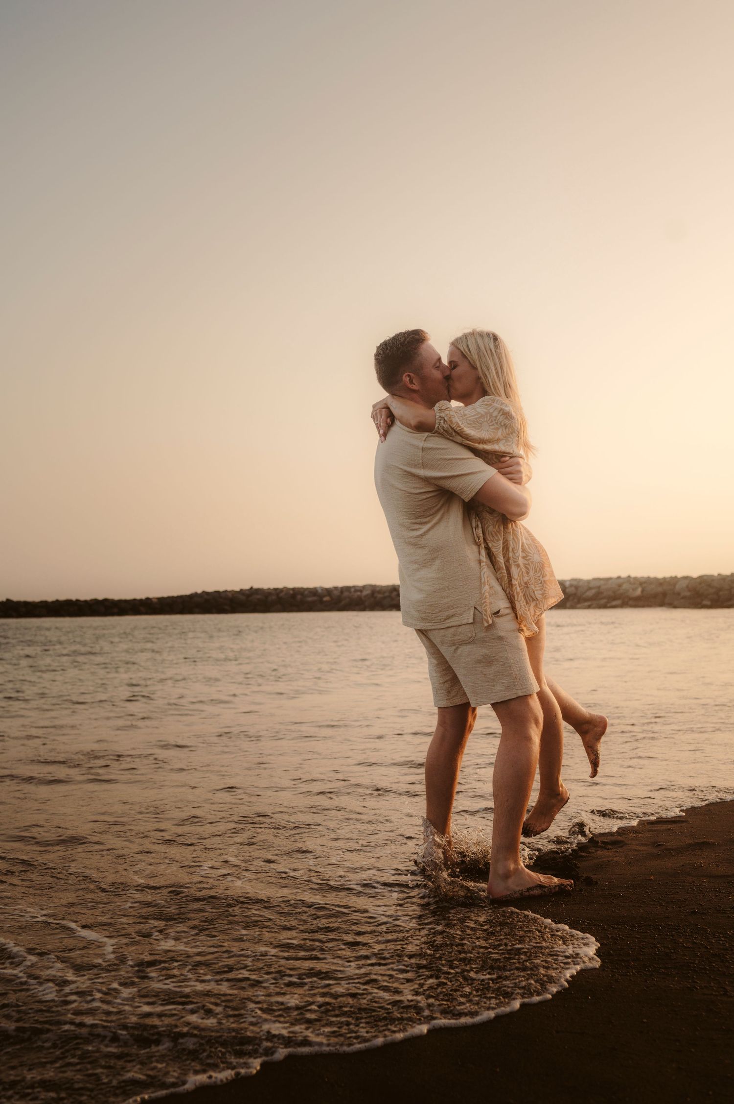 Romantic couple hugging in water during sunset, Playa del Duque Tenerife