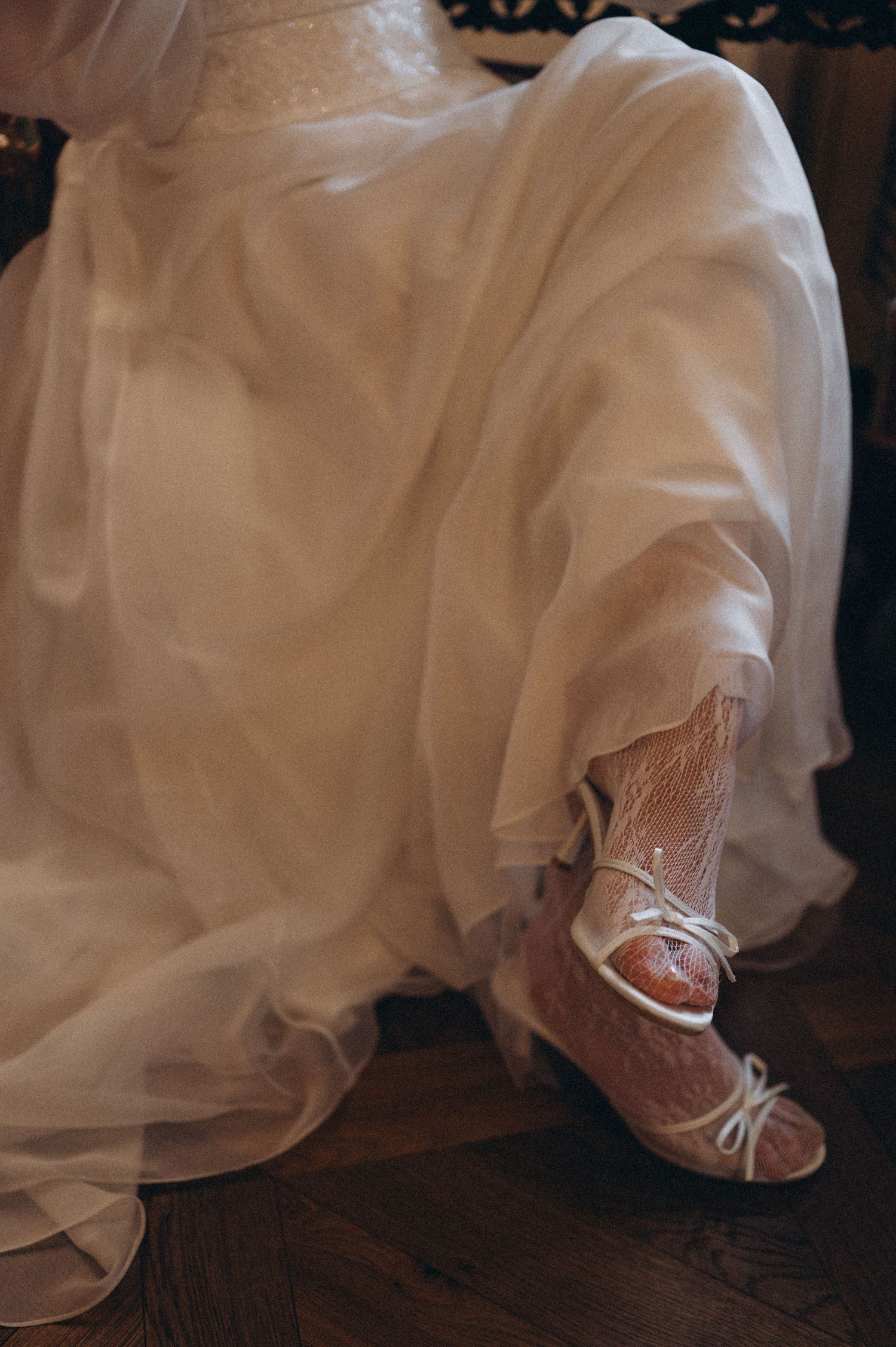 ridal fashion detail focusing on wedding shoes and crossed legs during a bridal portrait.