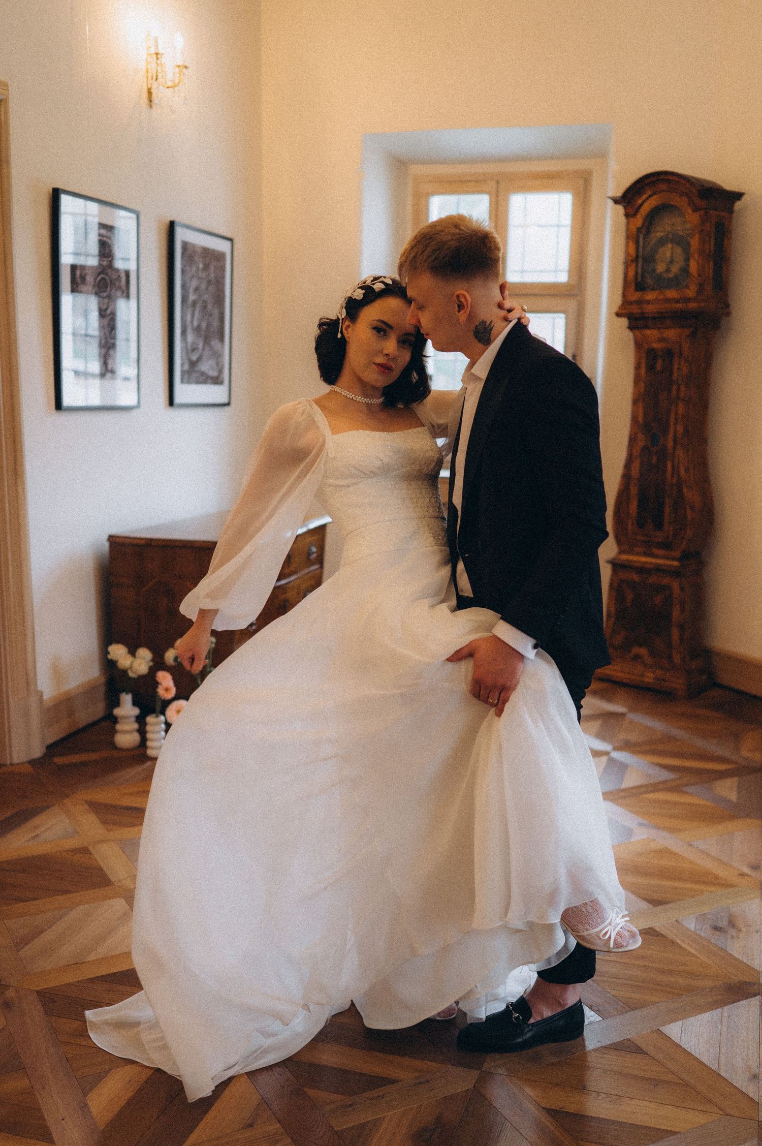 Bride and groom sharing a cinematic dip kiss in a luxurious vintage-style venue.