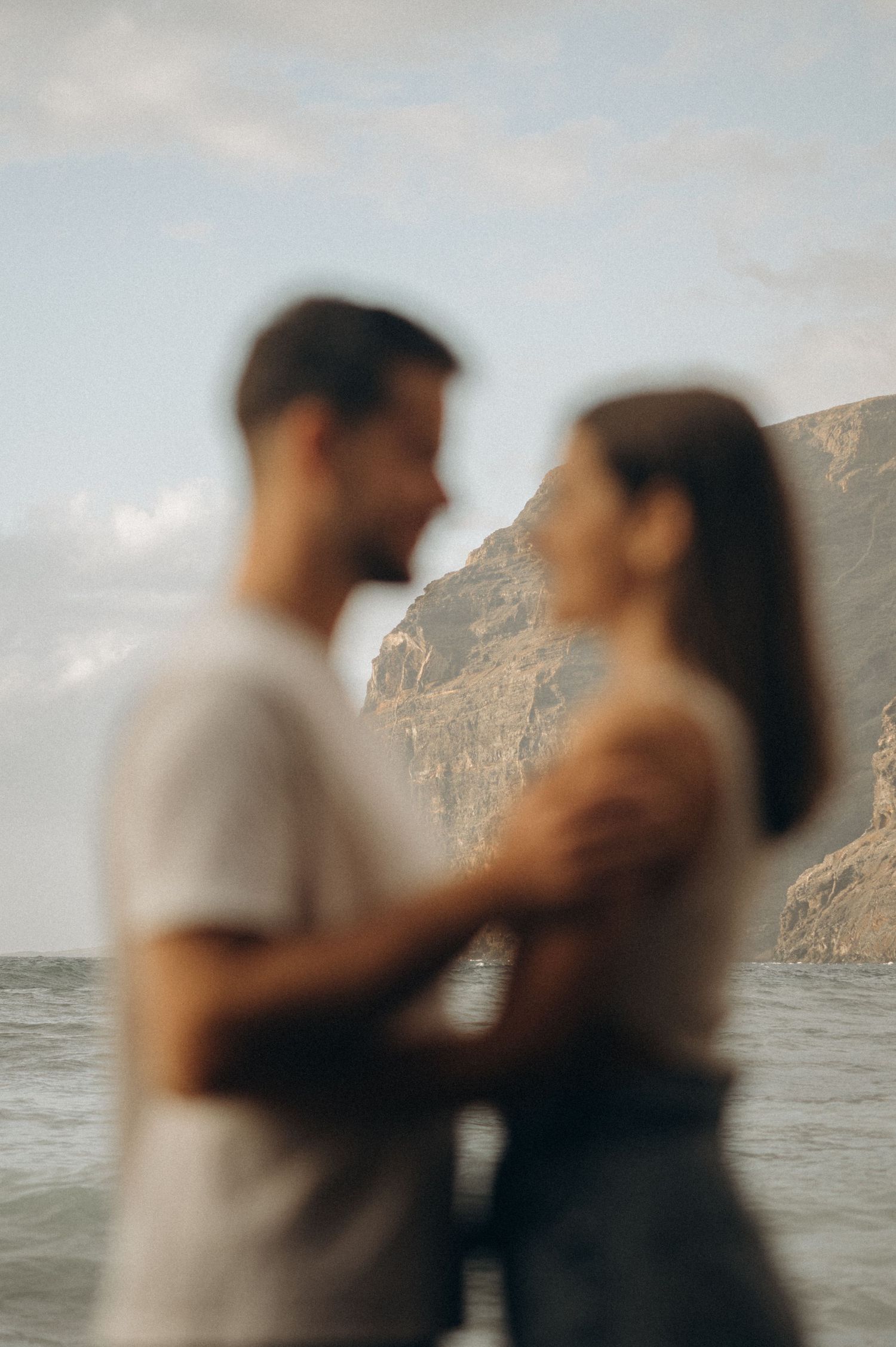 Woman holding man and smiling lovingly on Playa de Los Guíos beach, Tenerife