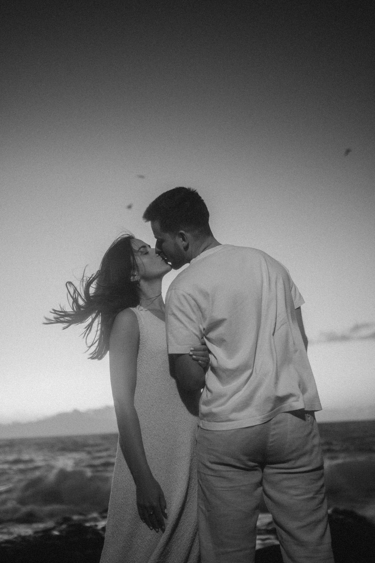 Romantic black and white sequence of young couple kissing in intimate embrace on Tenerife