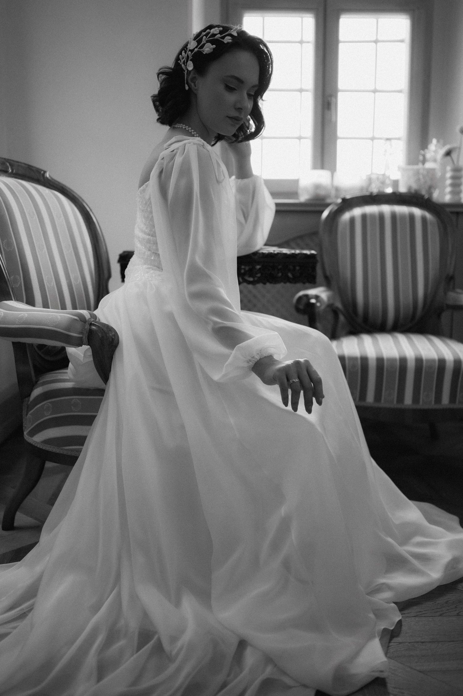 Timeless black and white bridal portrait of the bride in an elegant seated pose.