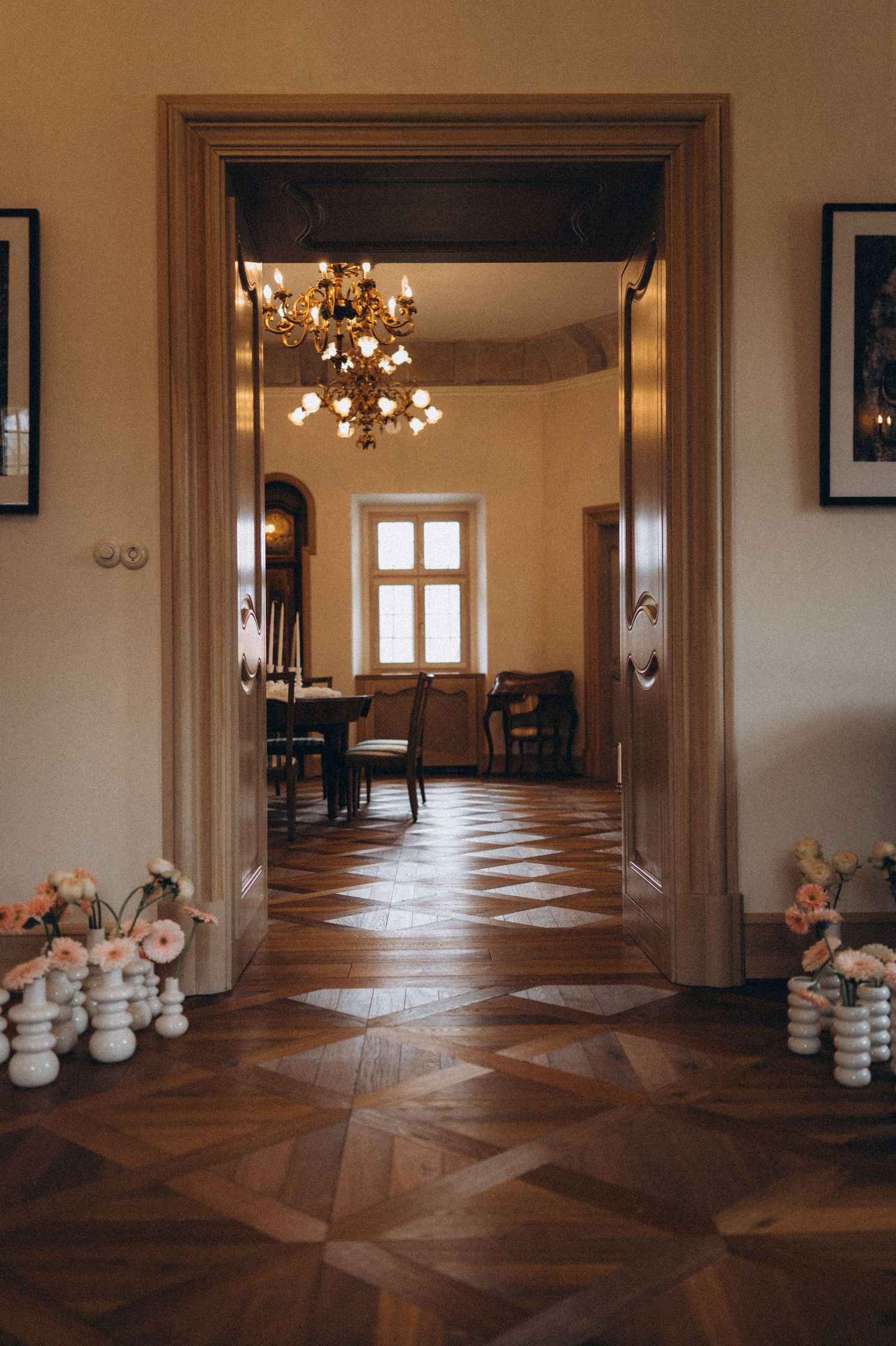 Wedding reception venue captured through open entrance doors, revealing elegant table styling and floral décor.