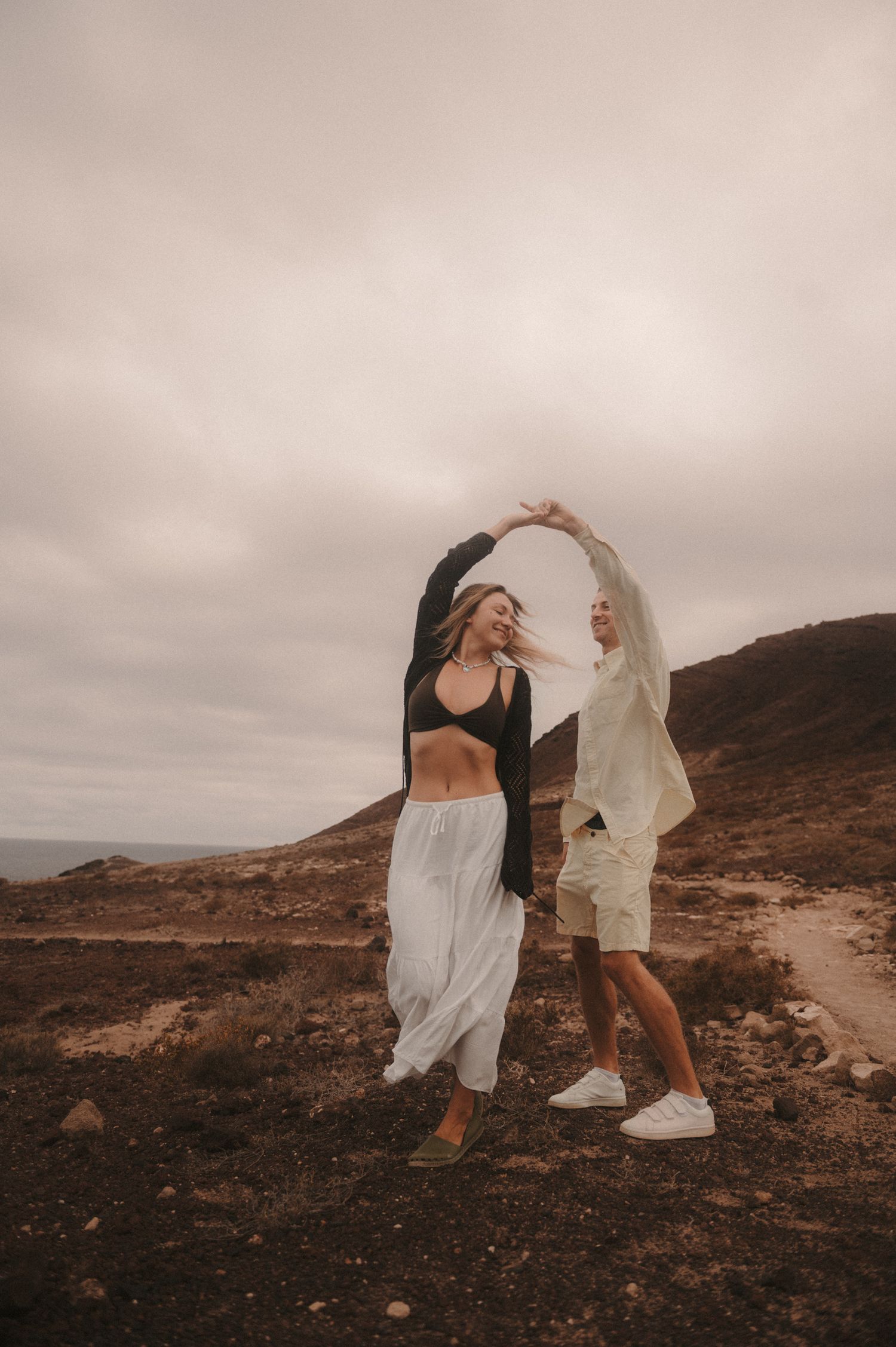 Loving couple dancing under Montaña Roja during a romantic photoshoot in Tenerife