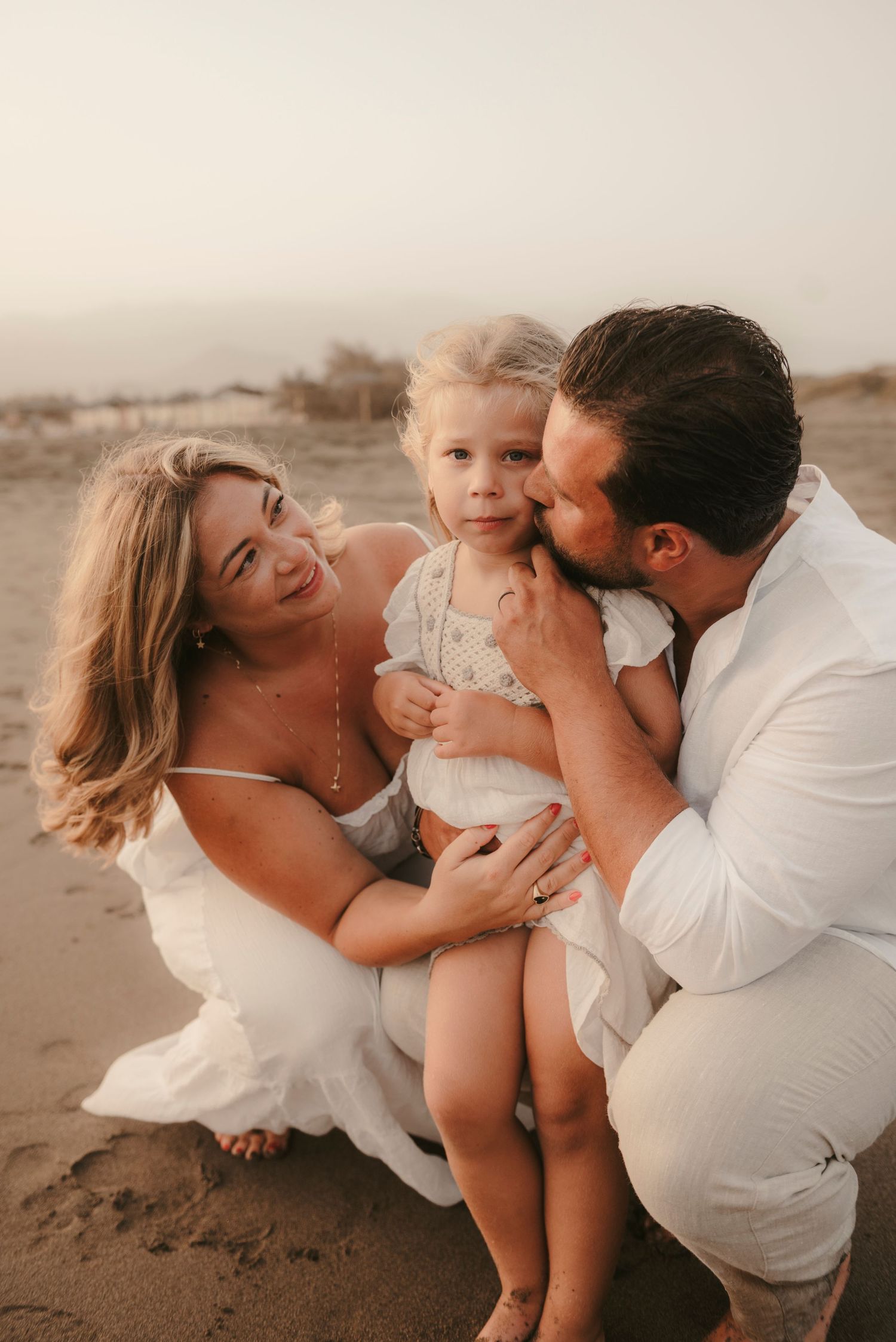 Loving close-up of a family cuddling together on the beach at Playa La Tejita