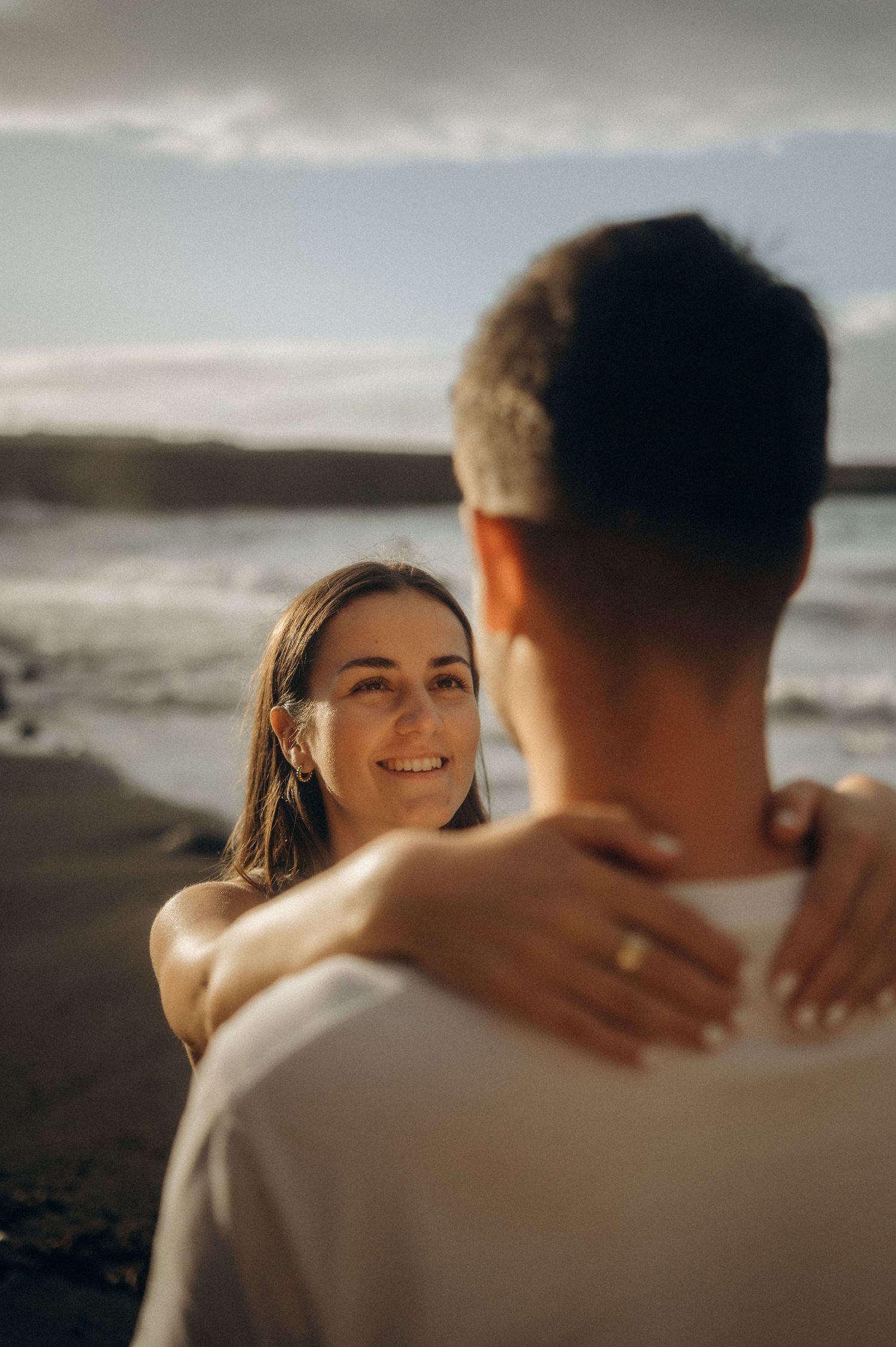 Couple’s engagement moment: hand kiss with ring on Playa de Los Guíos, Tenerife