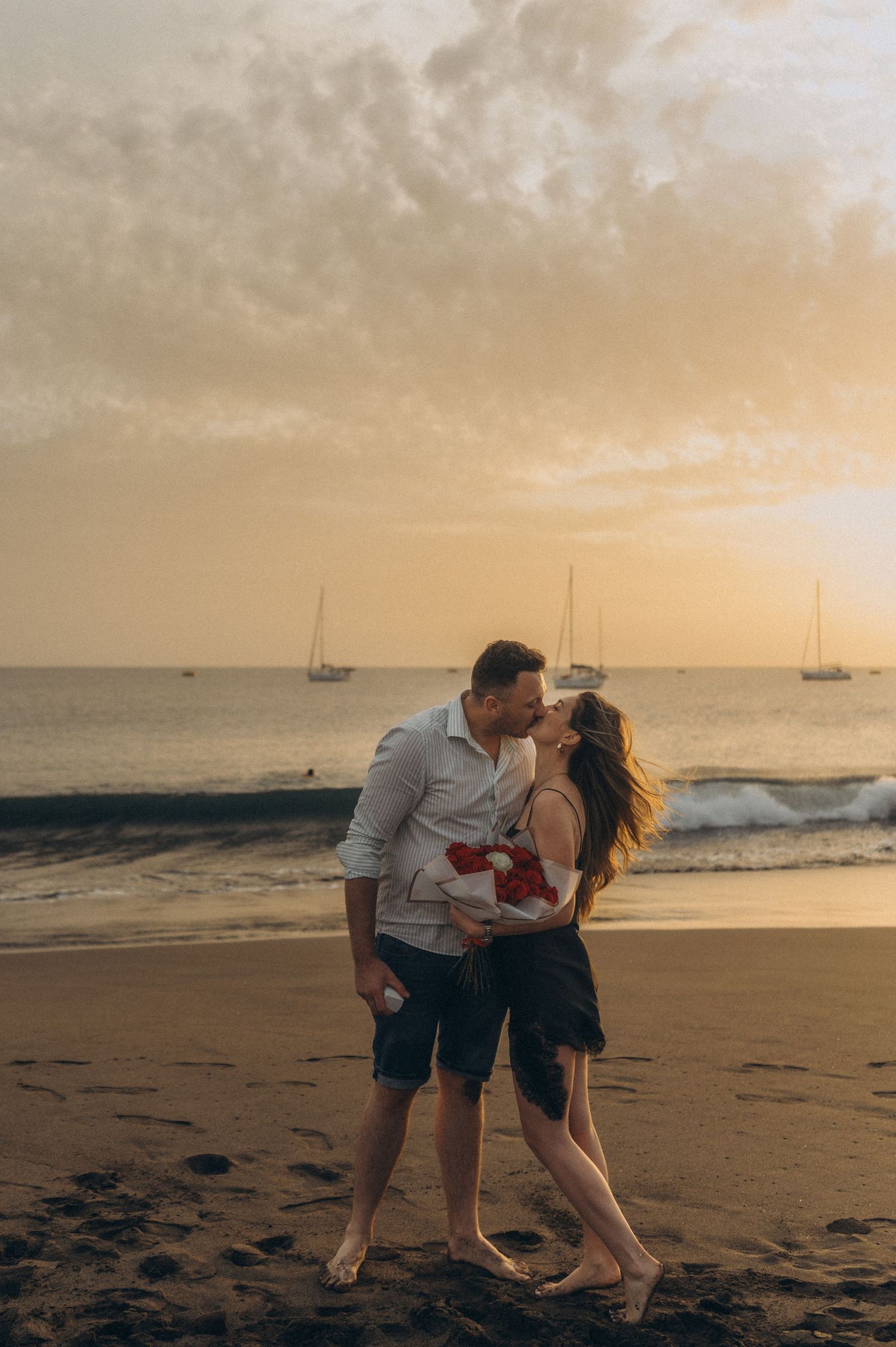 Woman gazing lovingly into partner’s eyes at sunset on Playa de La Tejita, Tenerife