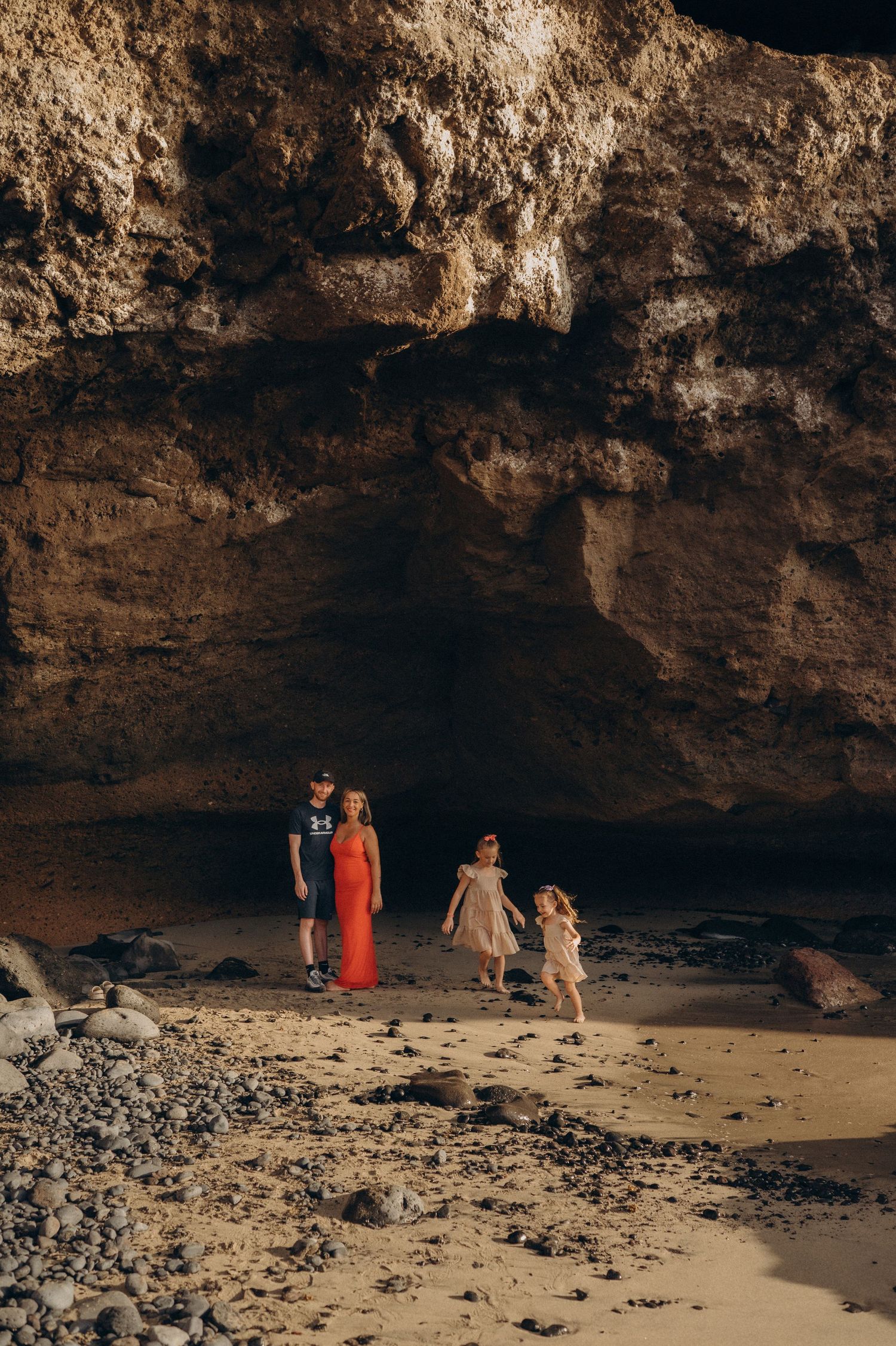 Majestic view of tiny family at the base of cliffs by the Atlantic Ocean in Tenerife
