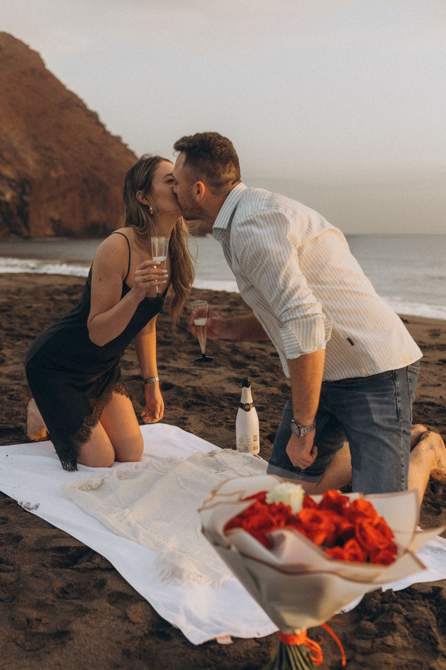Tender fingertip touch of couple’s hands with Atlantic Ocean behind, Playa de La Tejita, Tenerife