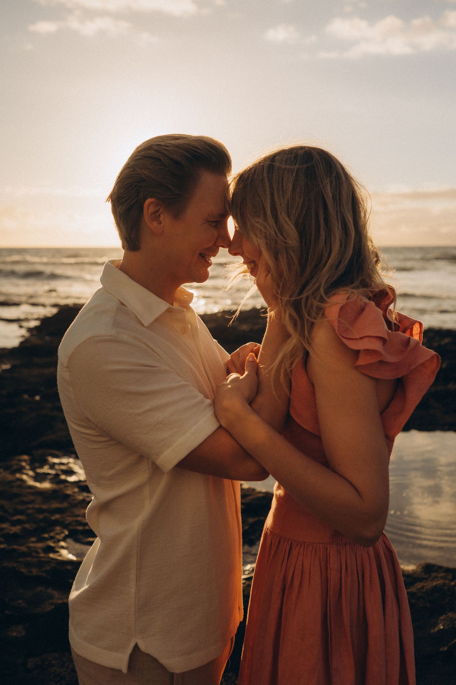 Parents touching foreheads at sunset with ocean view, romantic moment, Las Americas