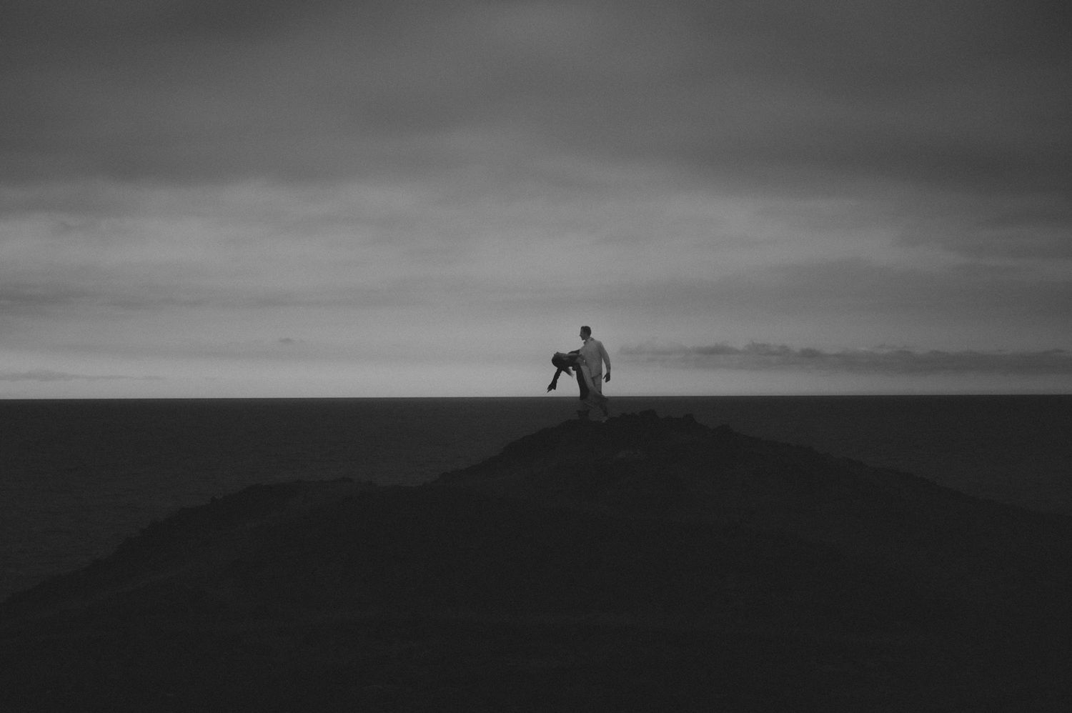 Cinematic shot of a couple holding each other with the magnificent ocean in the background, Tenerife