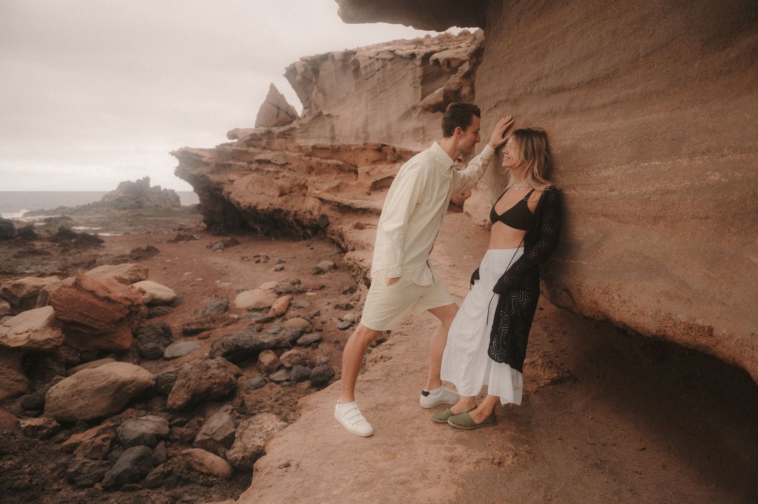 Romantic couple enjoying a photoshoot at the colorful cliffs near Montaña Roja, Tenerife