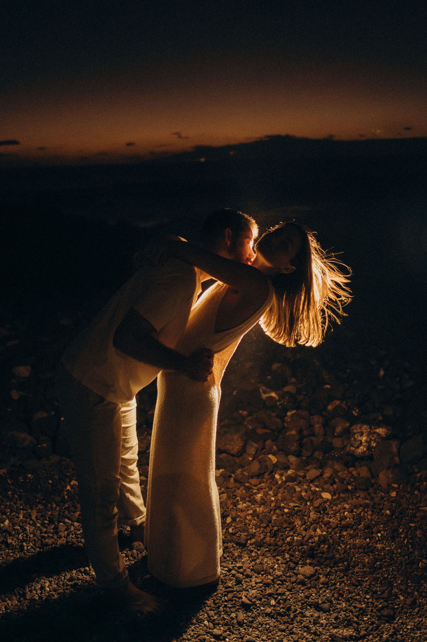 Young couple enjoying intimate moment with lights on a beach in south Tenerife at night