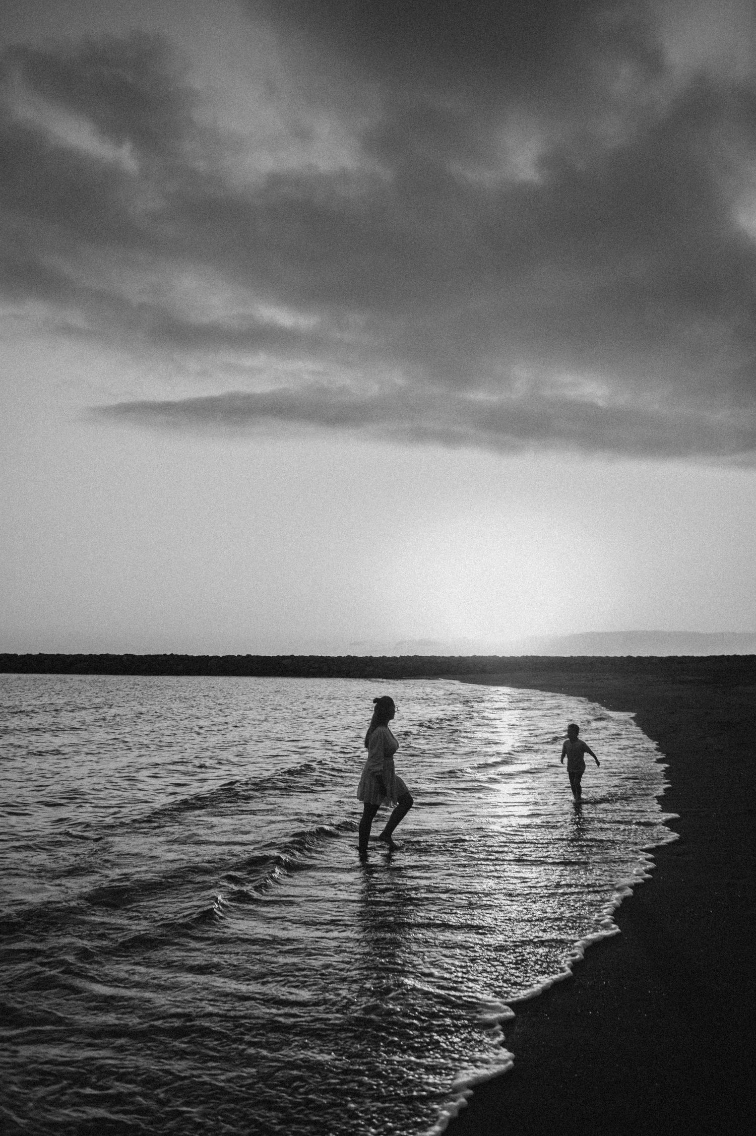 Monochrome image of mom and child sharing quiet time at sunset, Playa del Duque