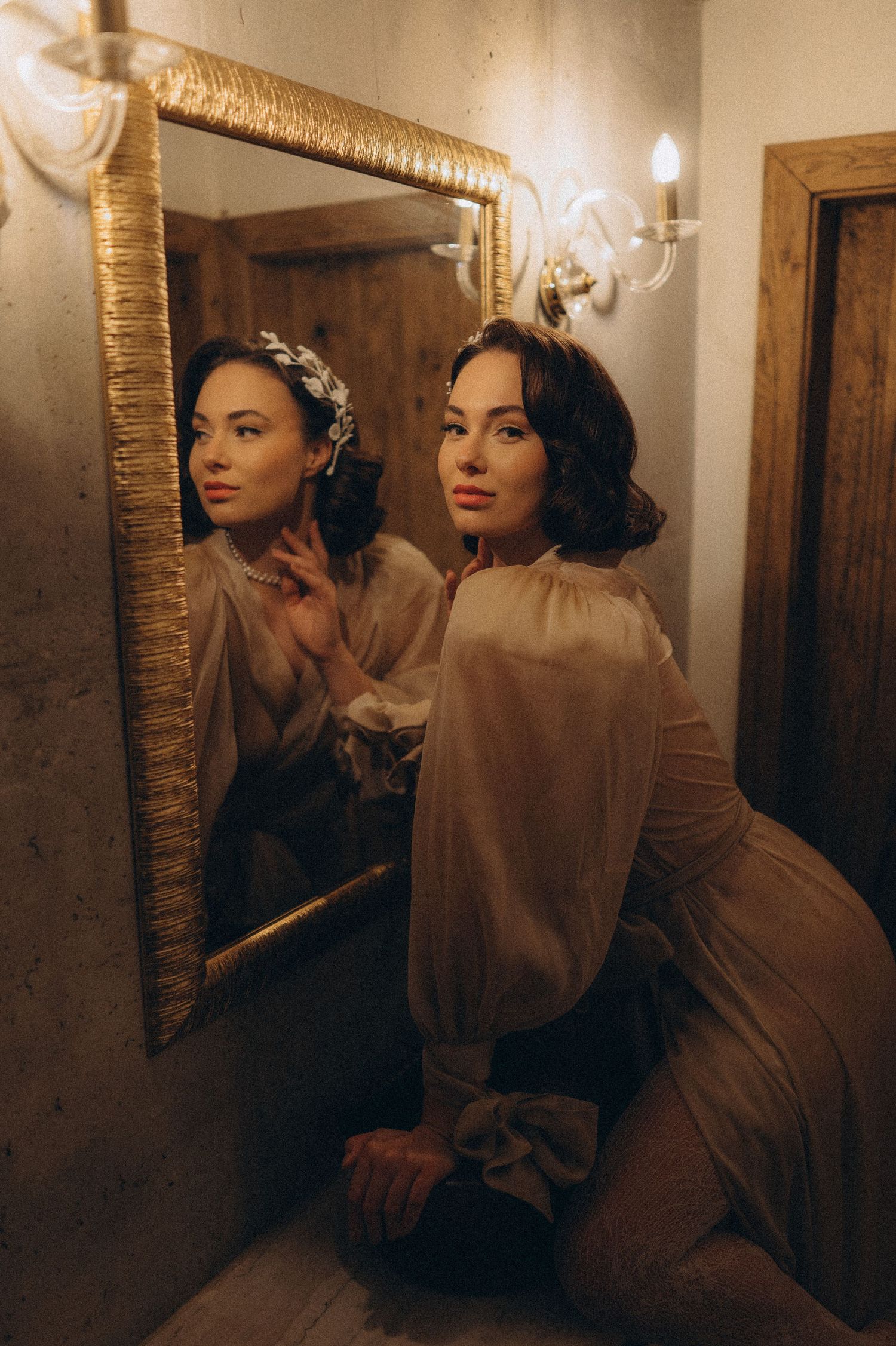 Artistic bridal portrait featuring the bride and her reflection in an ornate gold-framed mirror.