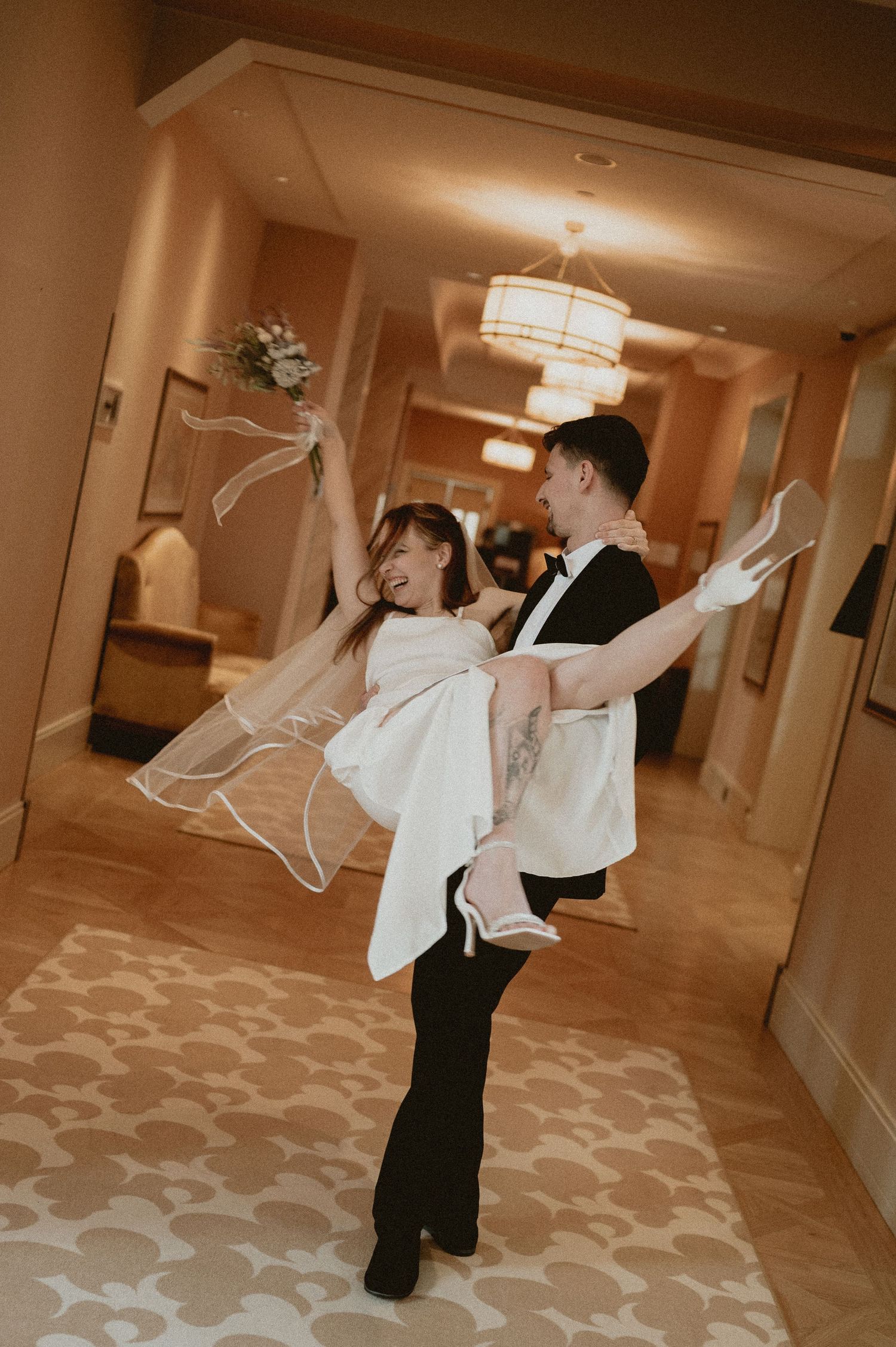 A joyful dance moment captured in a hotel hallway during a wedding celebration.