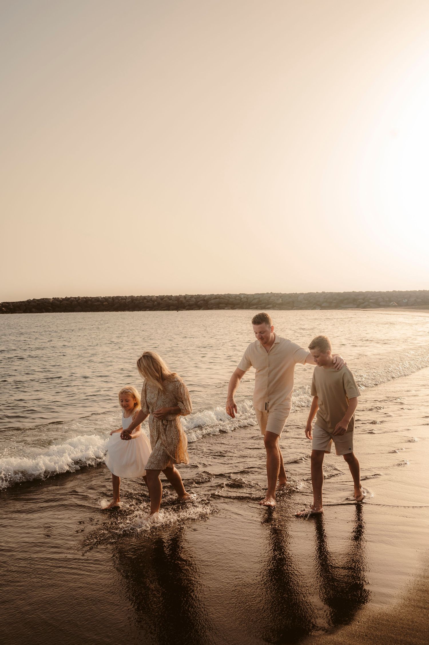 Family moment on beach enjoying their family time and sunset, Playa del Duque