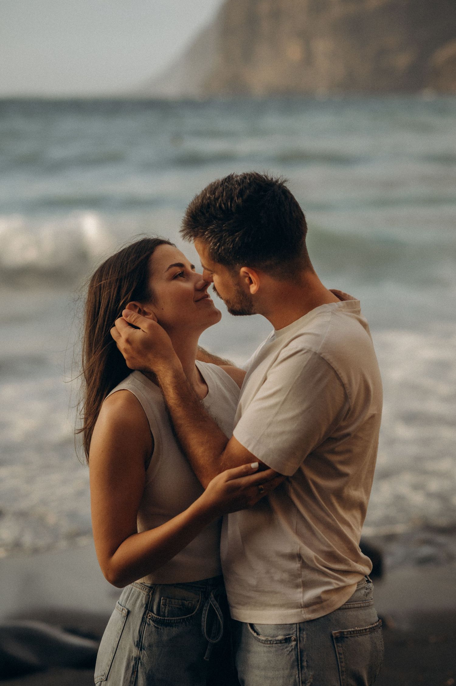 Intimate moment of romantic couple looking at each other on Playa de Los Guíos, Tenerife