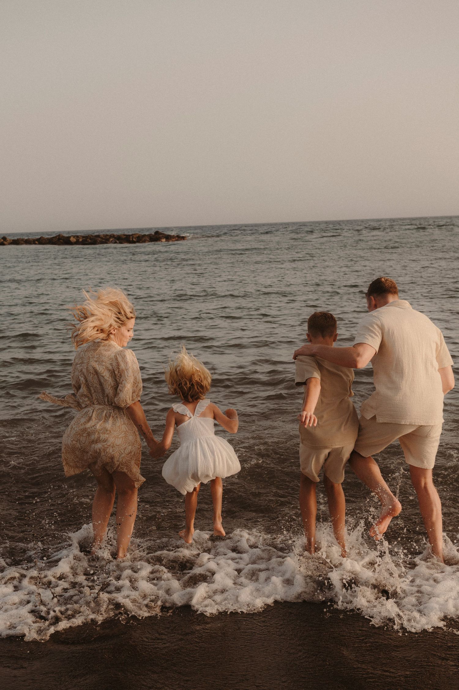 Parents and children entering sea holding hands, Playa del Duque