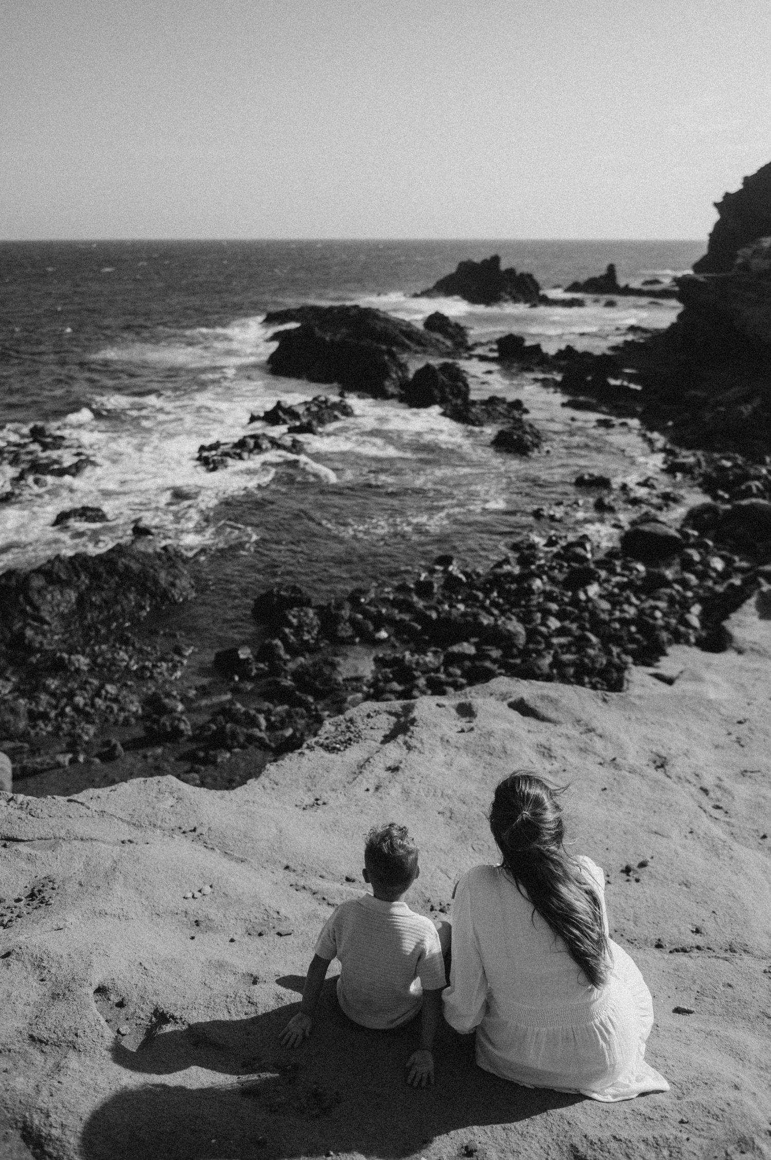 Mom and young son enjoying seaside view on Montaña Roja coast, Tenerife