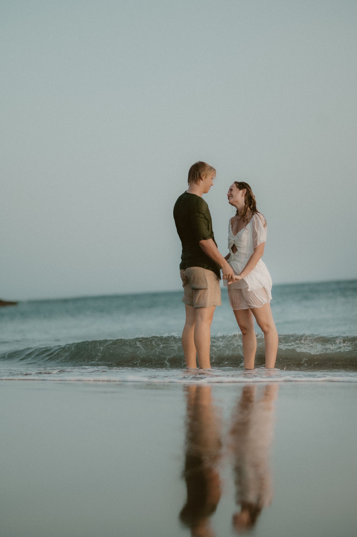 Young couple walking hand in hand along Playa Tejita with ocean waves