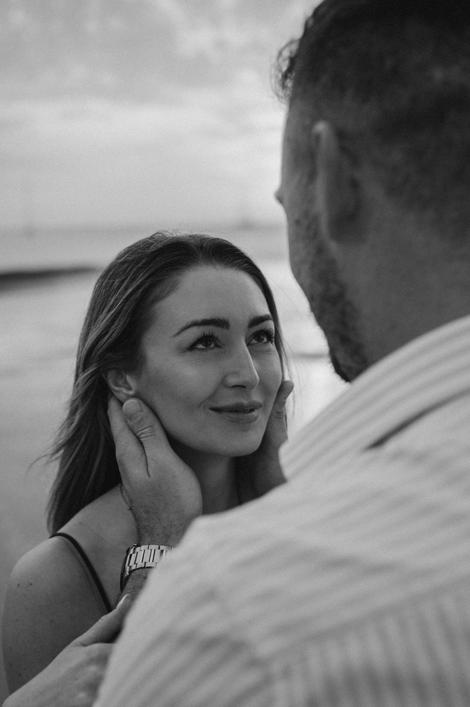 Young couple sharing intimate embrace while admiring Montaña Roja on Playa de La Tejita, Tenerife