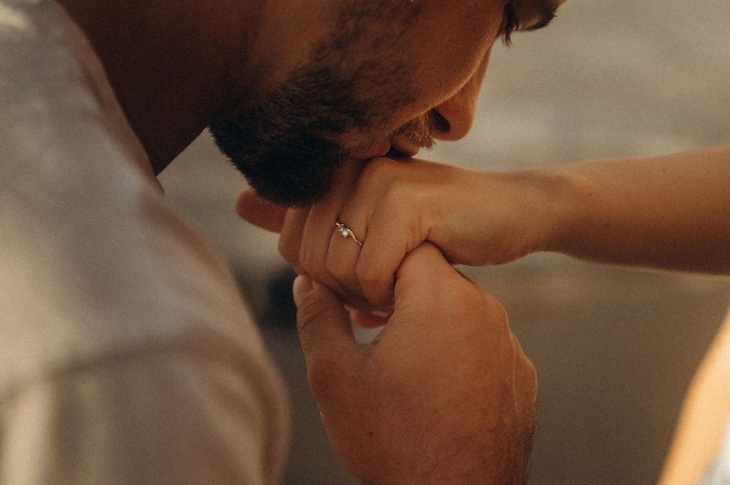 Couple’s engagement moment: hand kiss with ring on Playa de Los Guíos, Tenerife