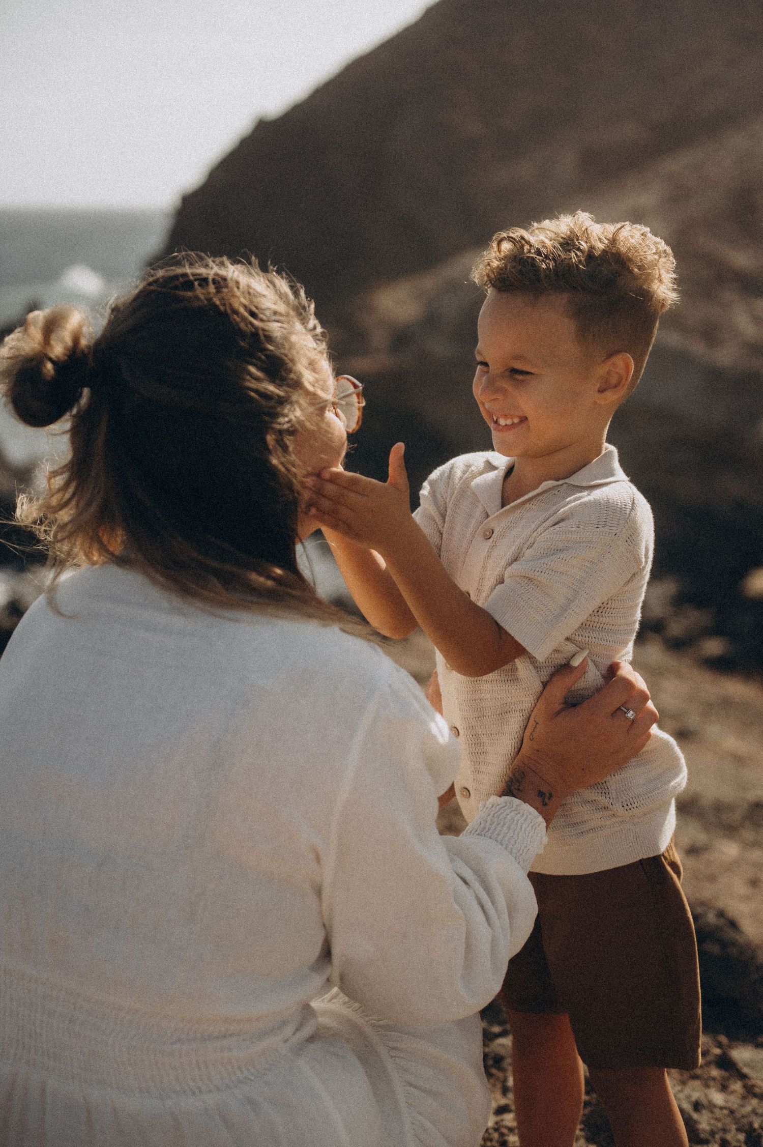 Young son laughing and touching mom’s hair in playful moment, Montaña Roja