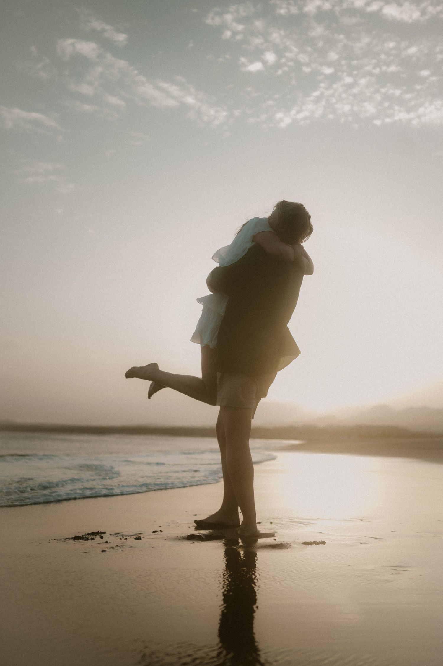 Couple kissing at sunset, groom holding his bride in his arms, Tenerife wedding photography on the beach