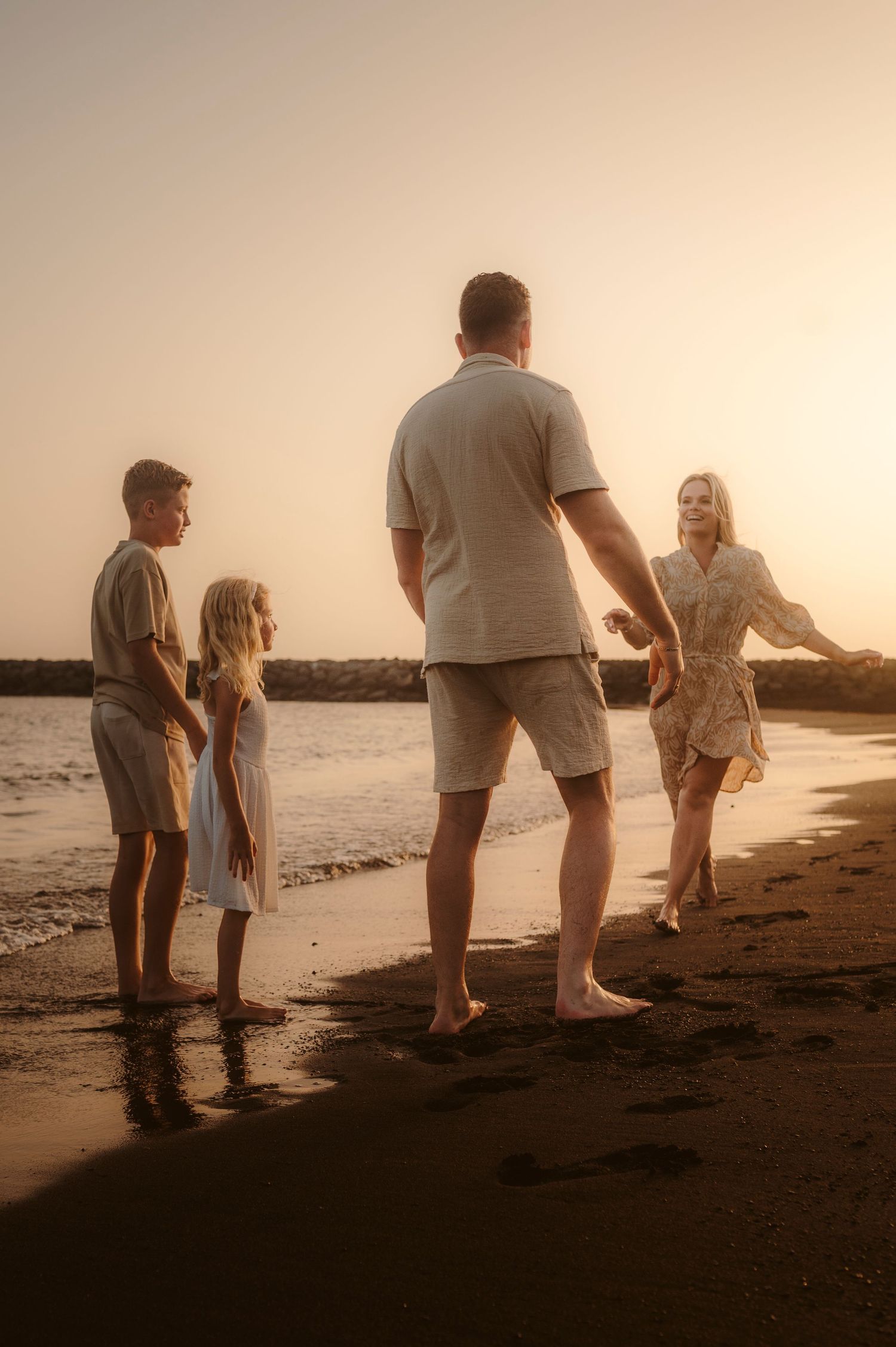 Family spending time together on volcanic beach at sunset, Tenerife