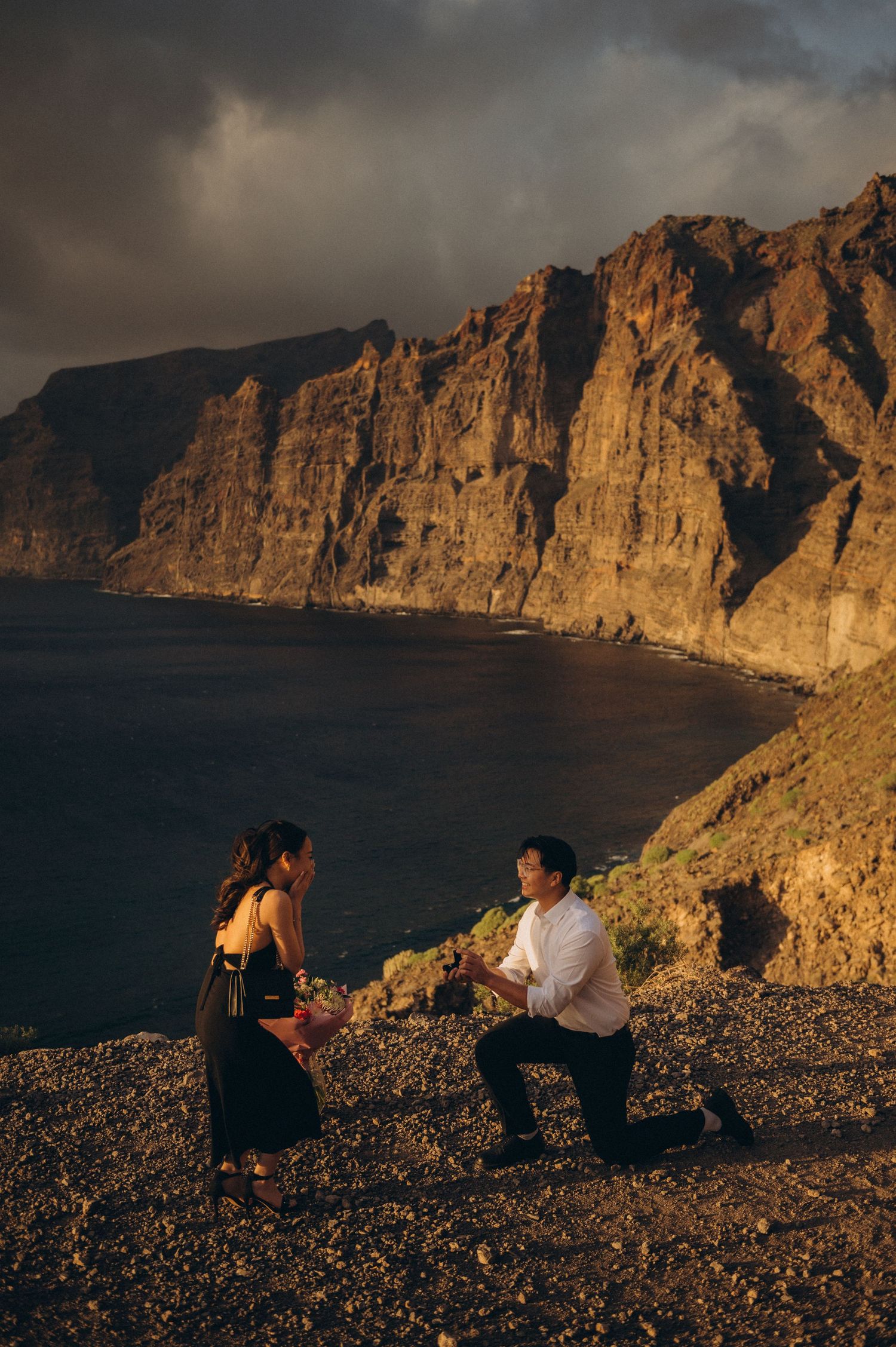 Surprise proposal in Los Gigantes, Tenerife at a dramatic cliffside ocean overlook during golden sunset.
