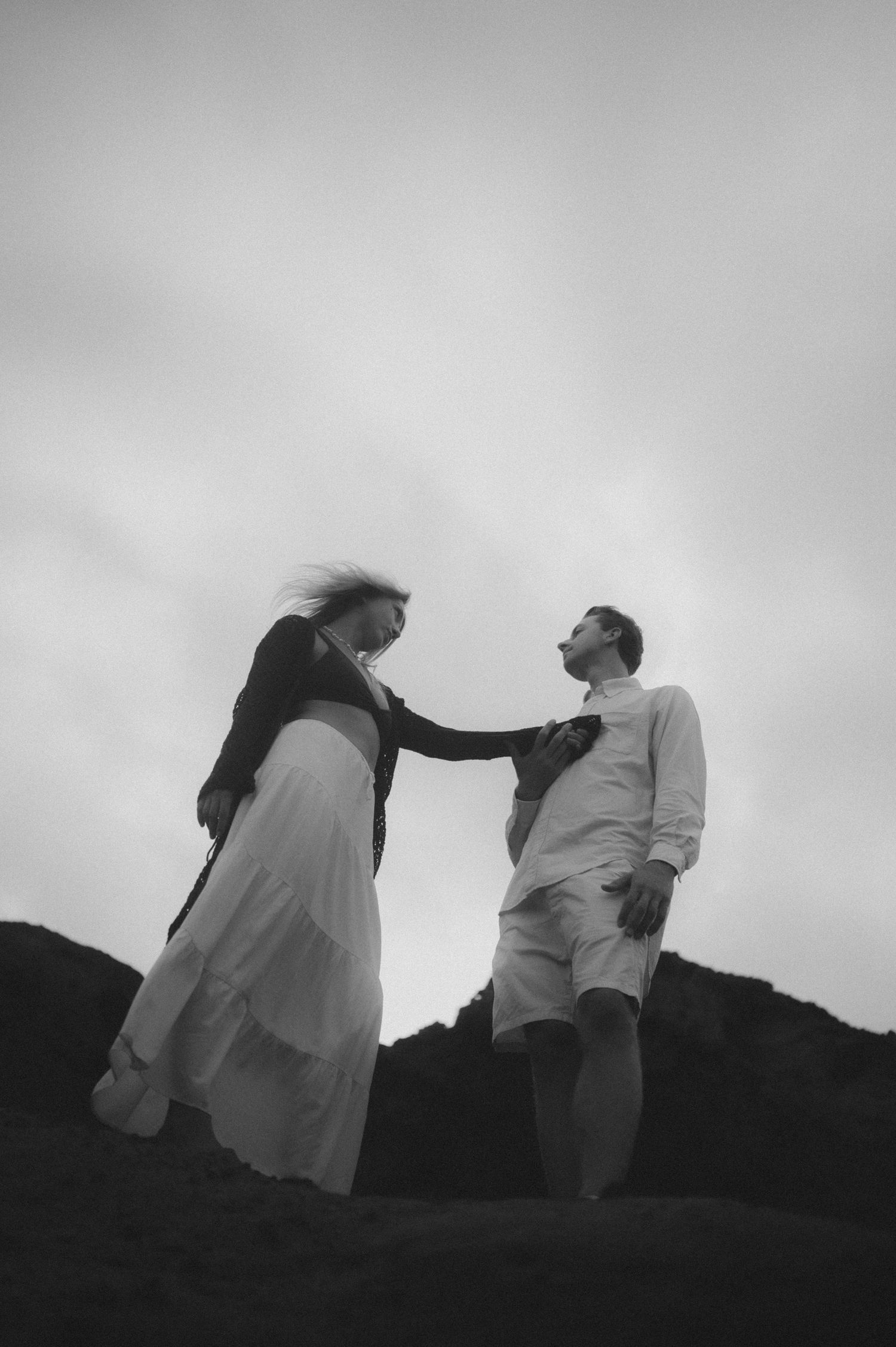 Young couple holding hands near Montaña Roja, sharing a romantic moment during a photoshoot in Tenerife