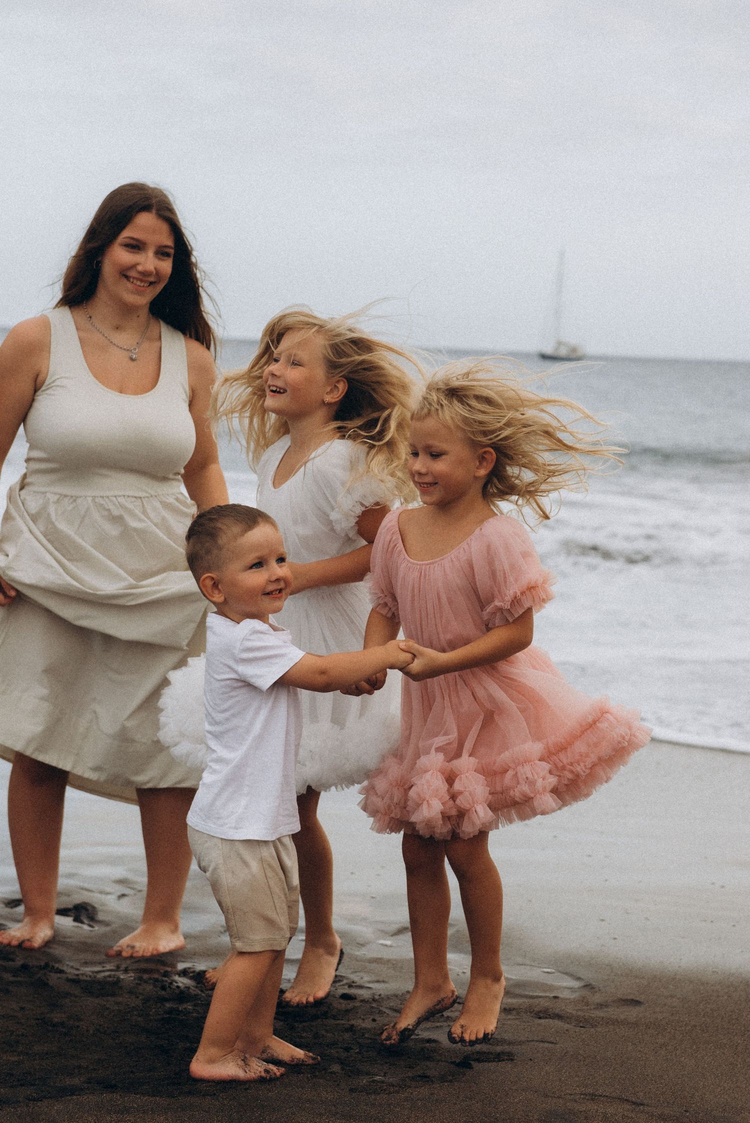 Toddlers enjoying beach fun together holding hands by ocean, Playa La Tejita