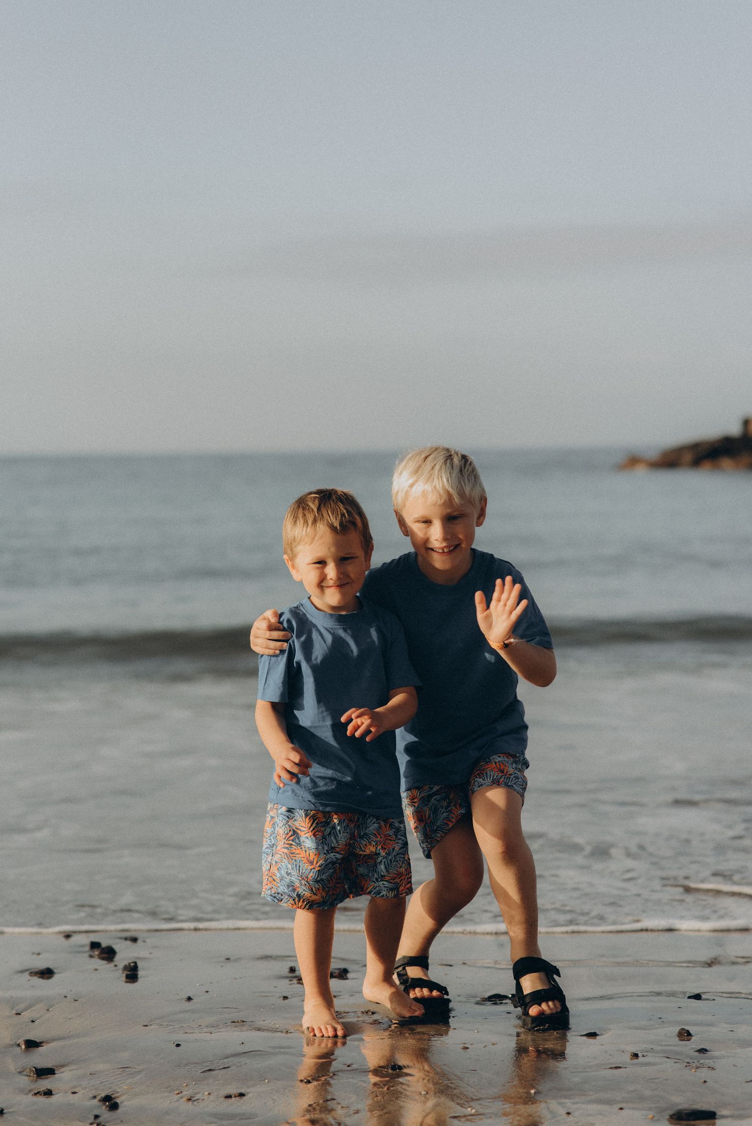 Long-distance view of two brothers standing by the ocean during a fresh Tenerife morning at Playa Fañabé