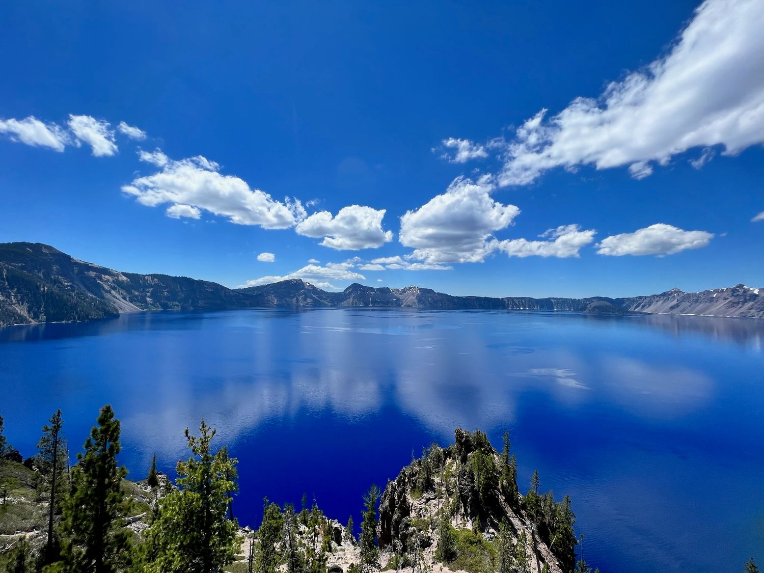 Crater Lake National Park blue lake white clouds green trees