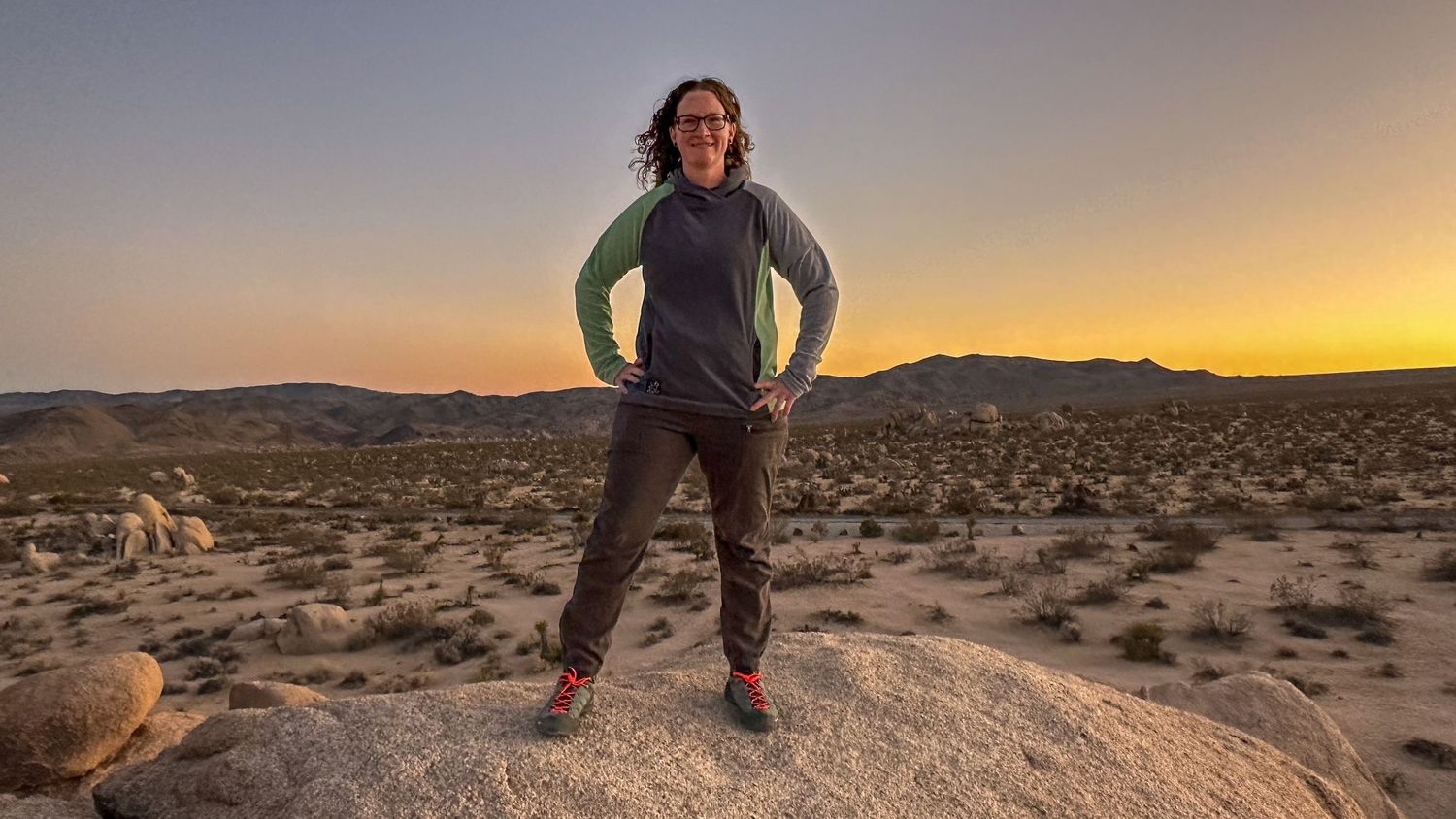 Photographer Jenny Casad in Joshua Tree National Park during sunset standing on jumbo rocks